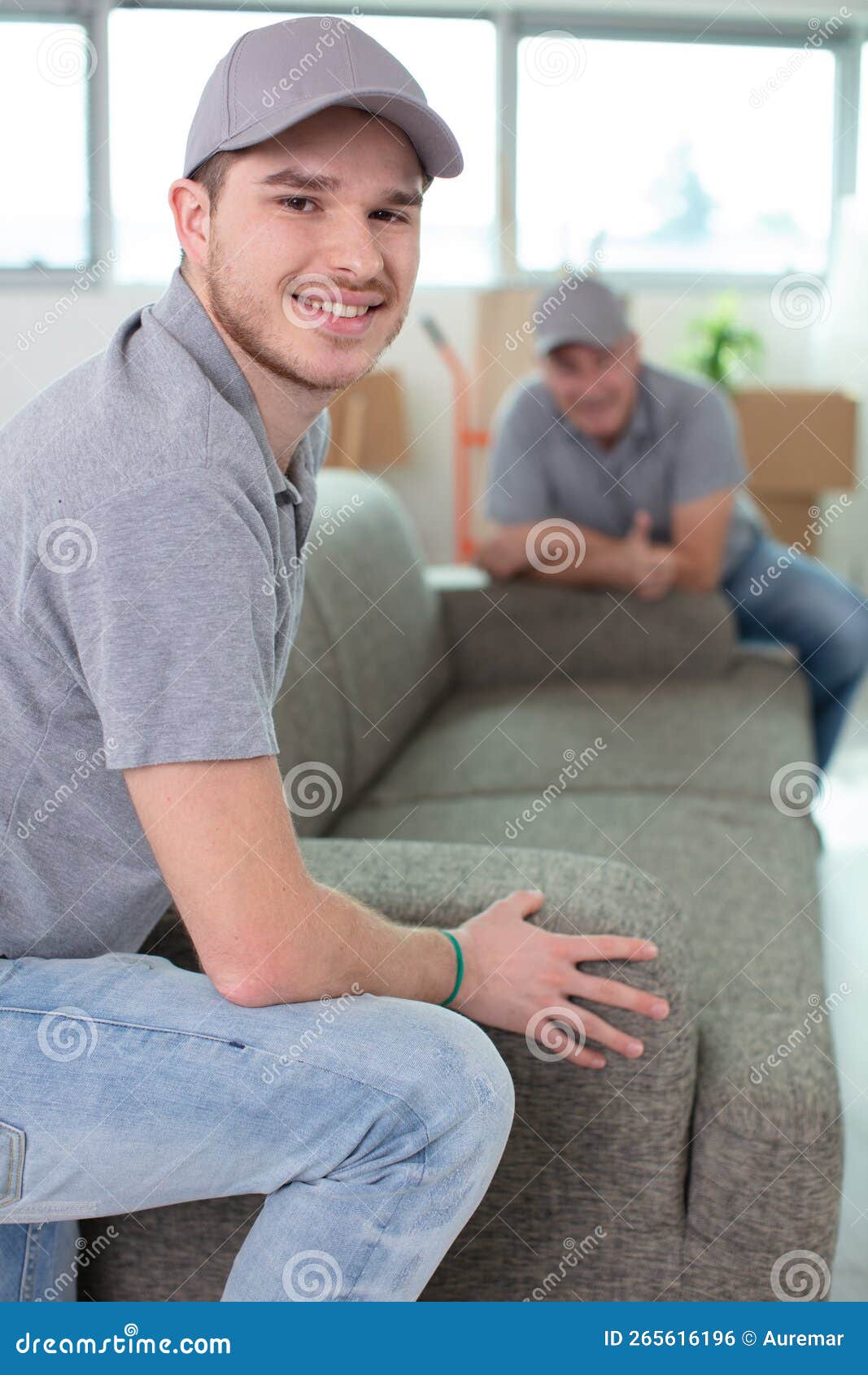 removals men carrying sofa and showing thumbs-up