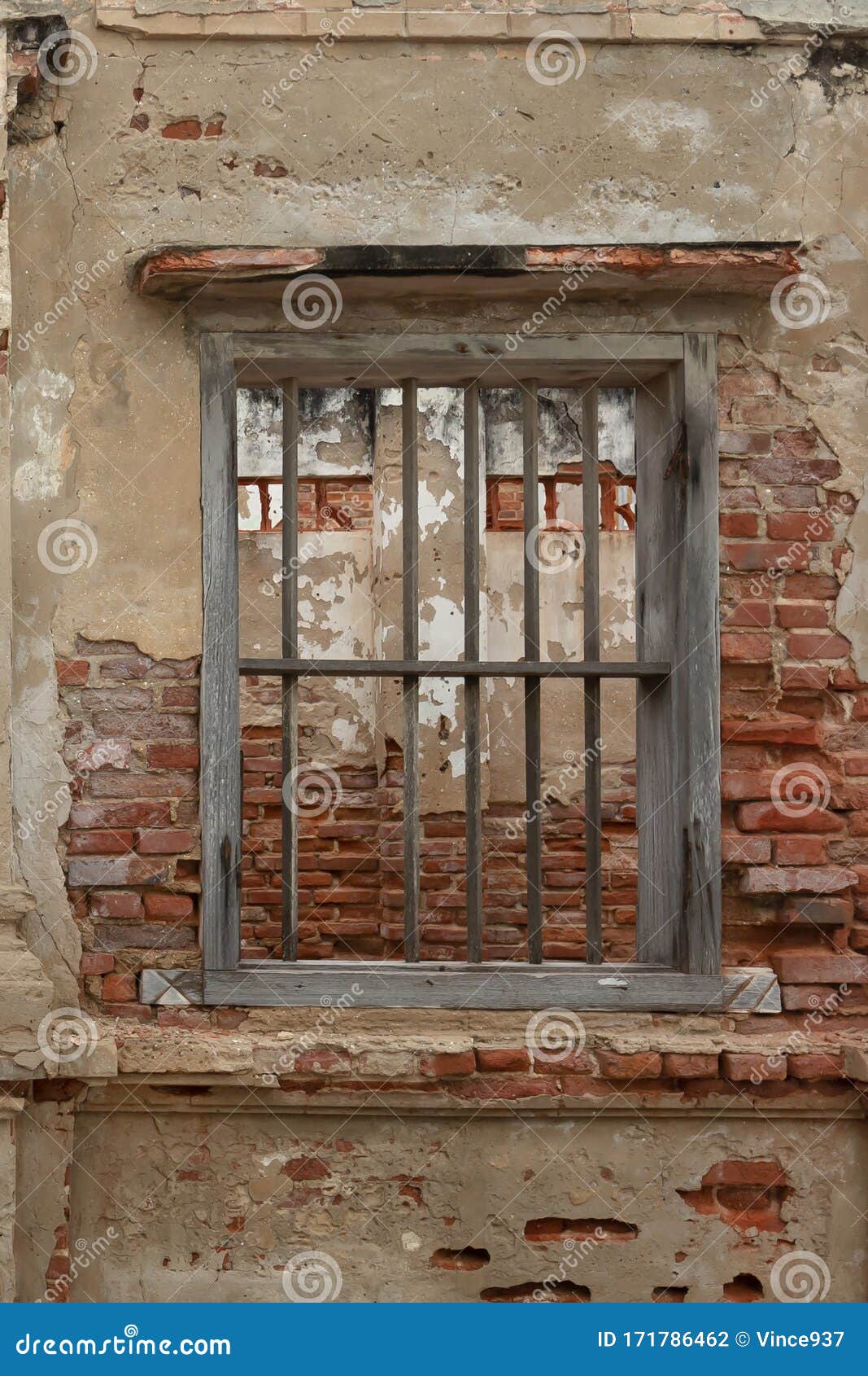 rendered concrete wall with exposed red brick and wooden jail cell like window abstract