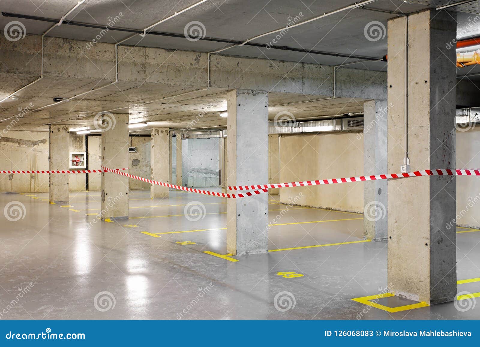 renewed underground car parking with yellow lot marking and warning tape