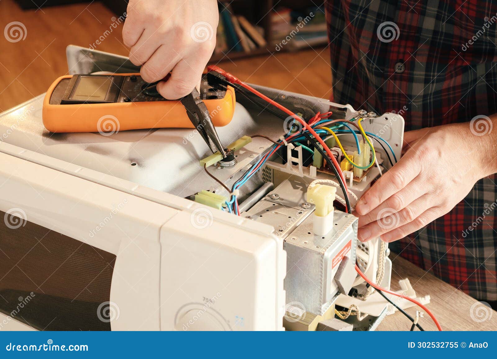 a repair engineer disassembles a microwave oven looking for a fault