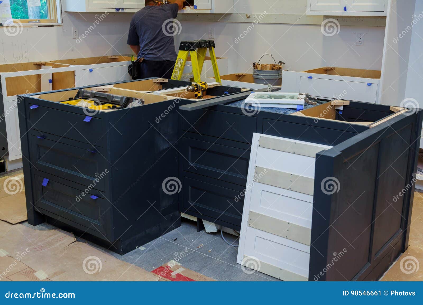 Repair Man In Overalls Repairing Cabinet Hinge In Kitchen Stock