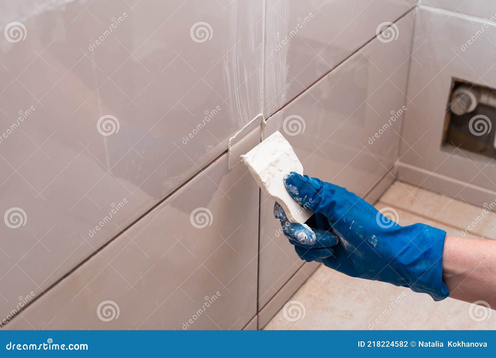 Repair and Wall Cladding with Tiles. the Master Rubbing the Tile Joints