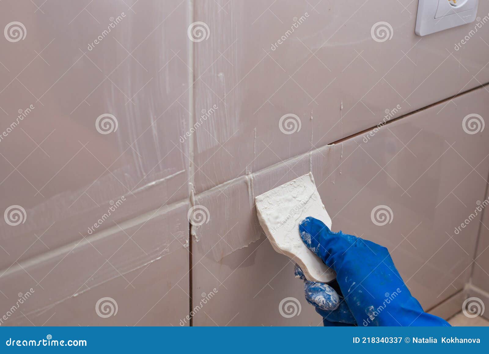Repair and Wall Cladding with Tiles. the Master Rubbing the Tile Joints