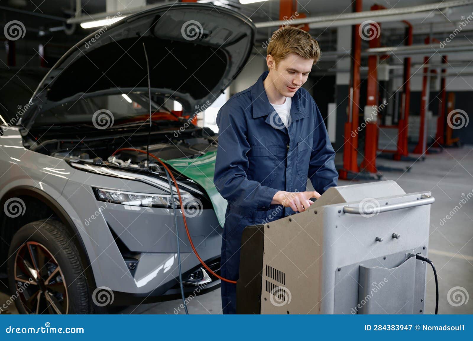 Repairman at Car Garage Doing Air Conditioner or Climate Control