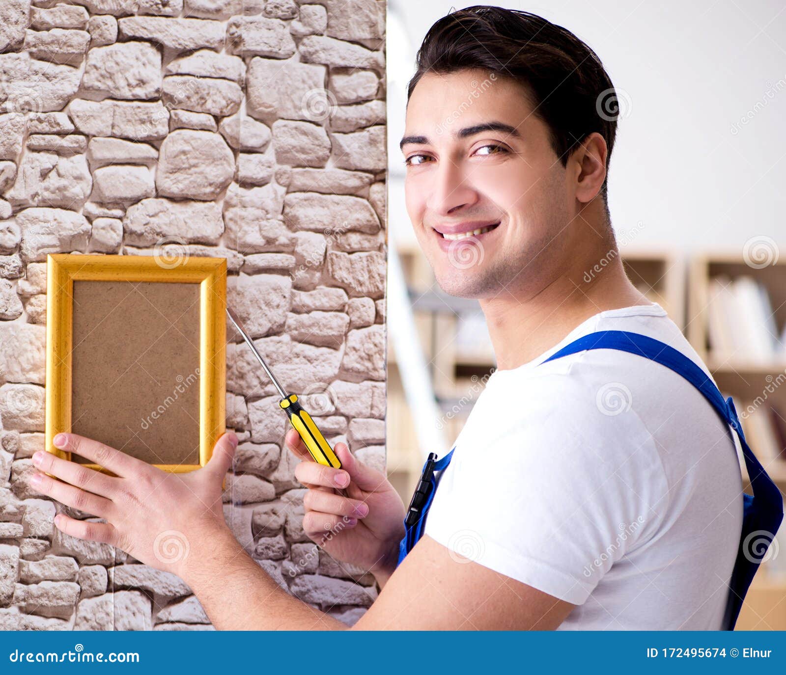 Repairman Putting Picture Frame Onto Wall Stock Photo Image of casual