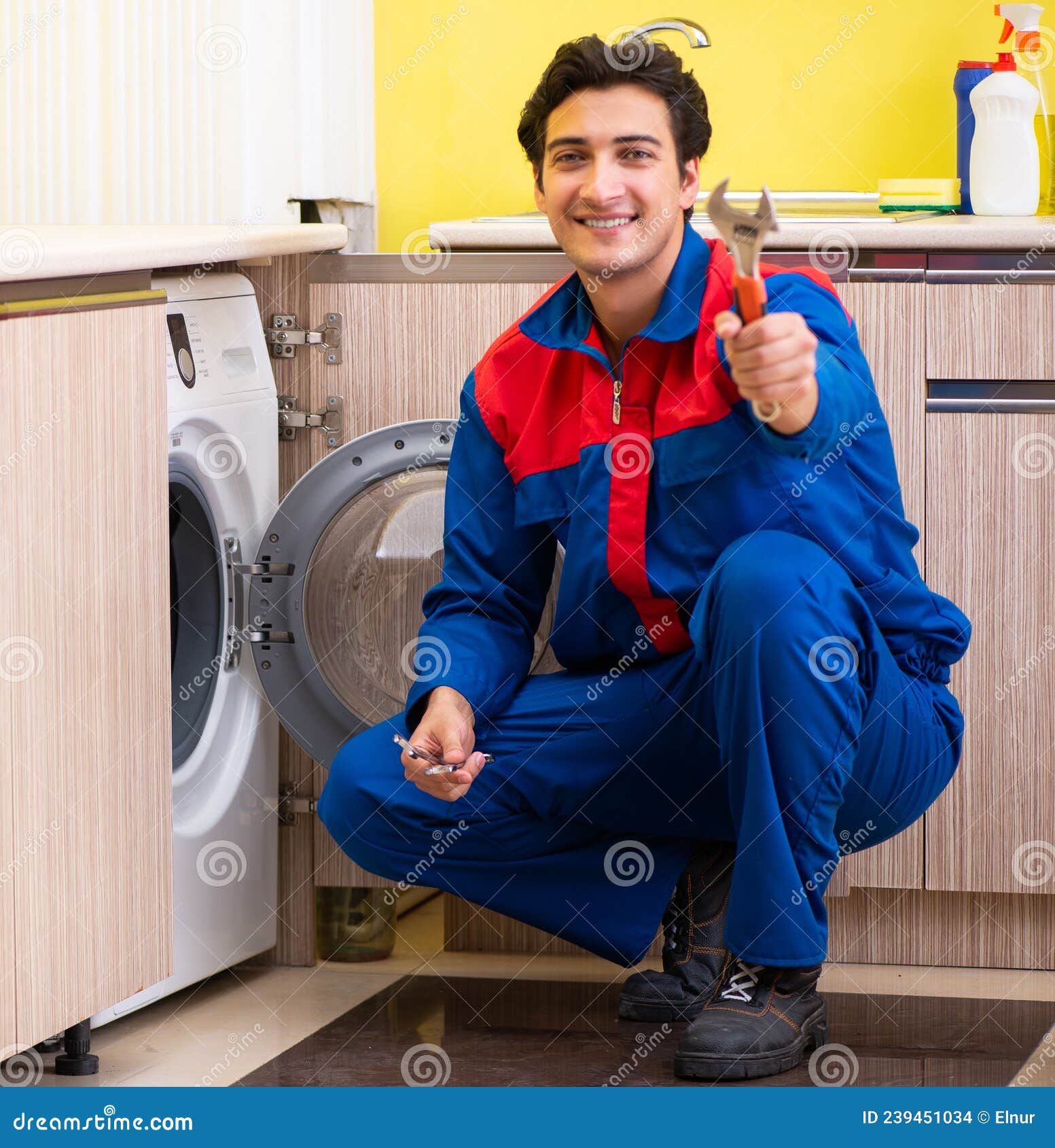 Repairman Repairing Washing Machine in the Kitchen Stock Photo Image