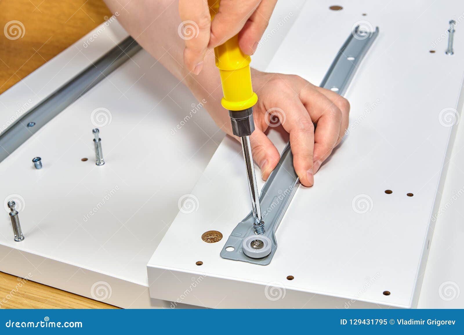 Repairman Is Screwing In Drawer Slide Bracket Using Screwd Stock