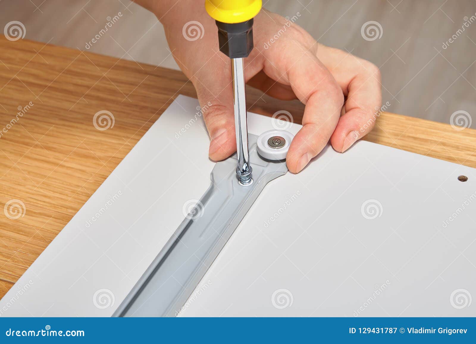 Joiner Is Mounting Slide Bracket For Drawer Using Screwdriver