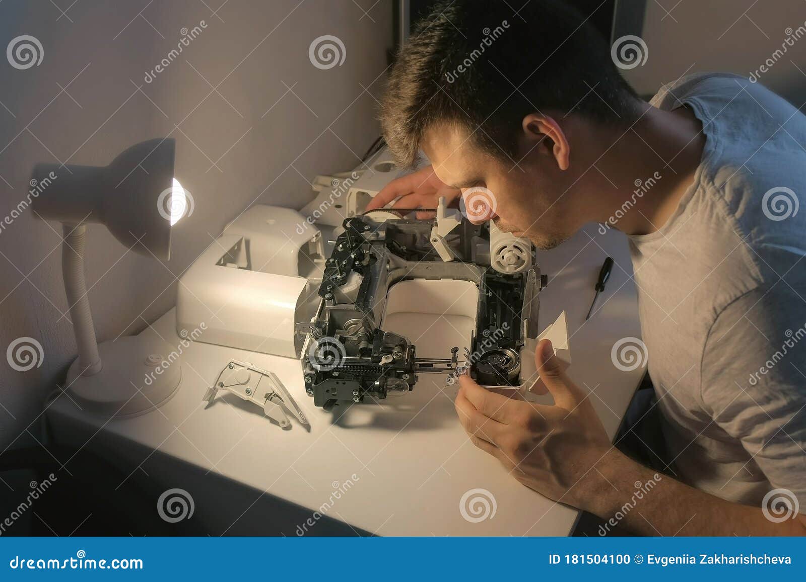 Repairman Testing Disassembles Sewing Machine in Repairing it