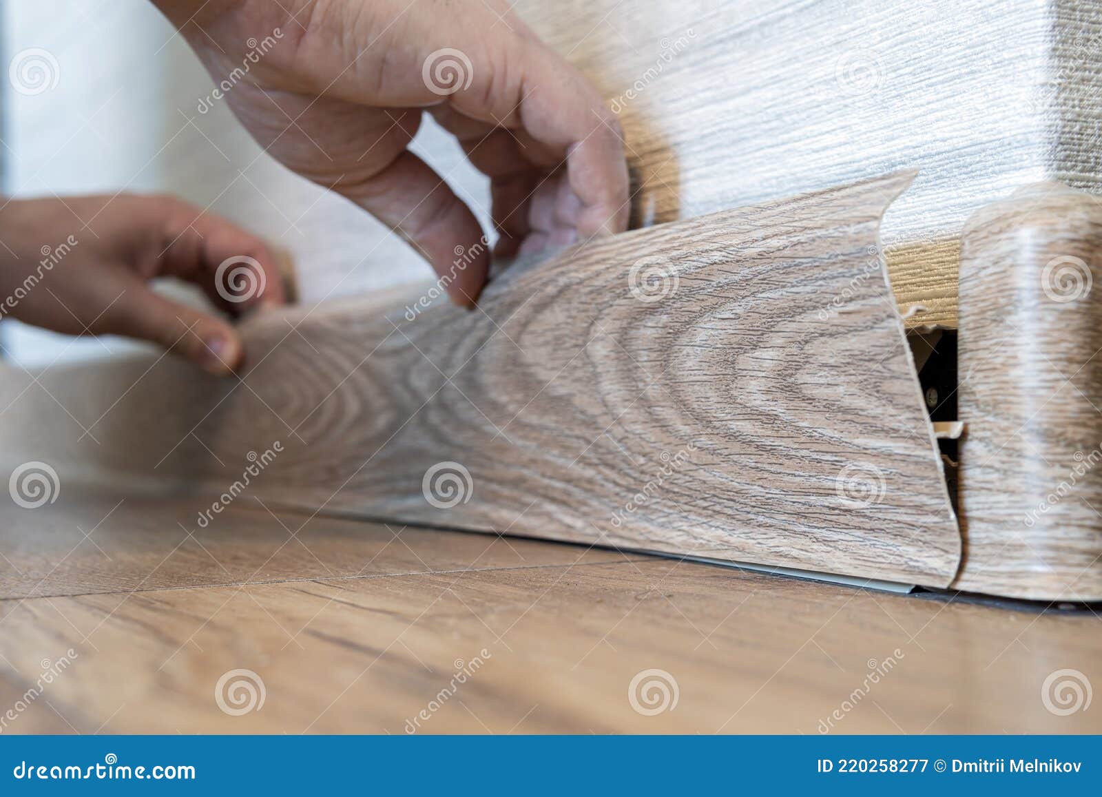 Replacement of the Plastic Skirting Board on the Floor. Man Hands