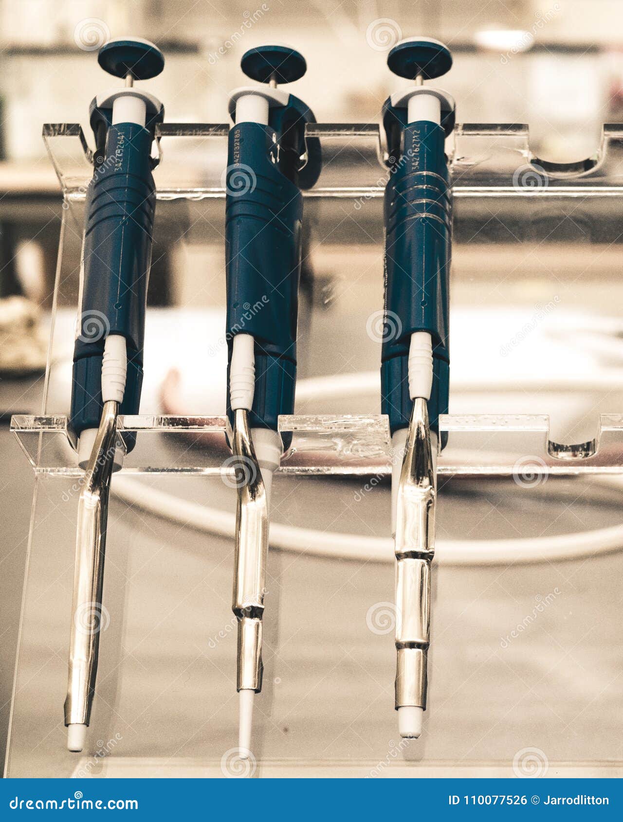 replicating pipettes on a stand in a research lab.