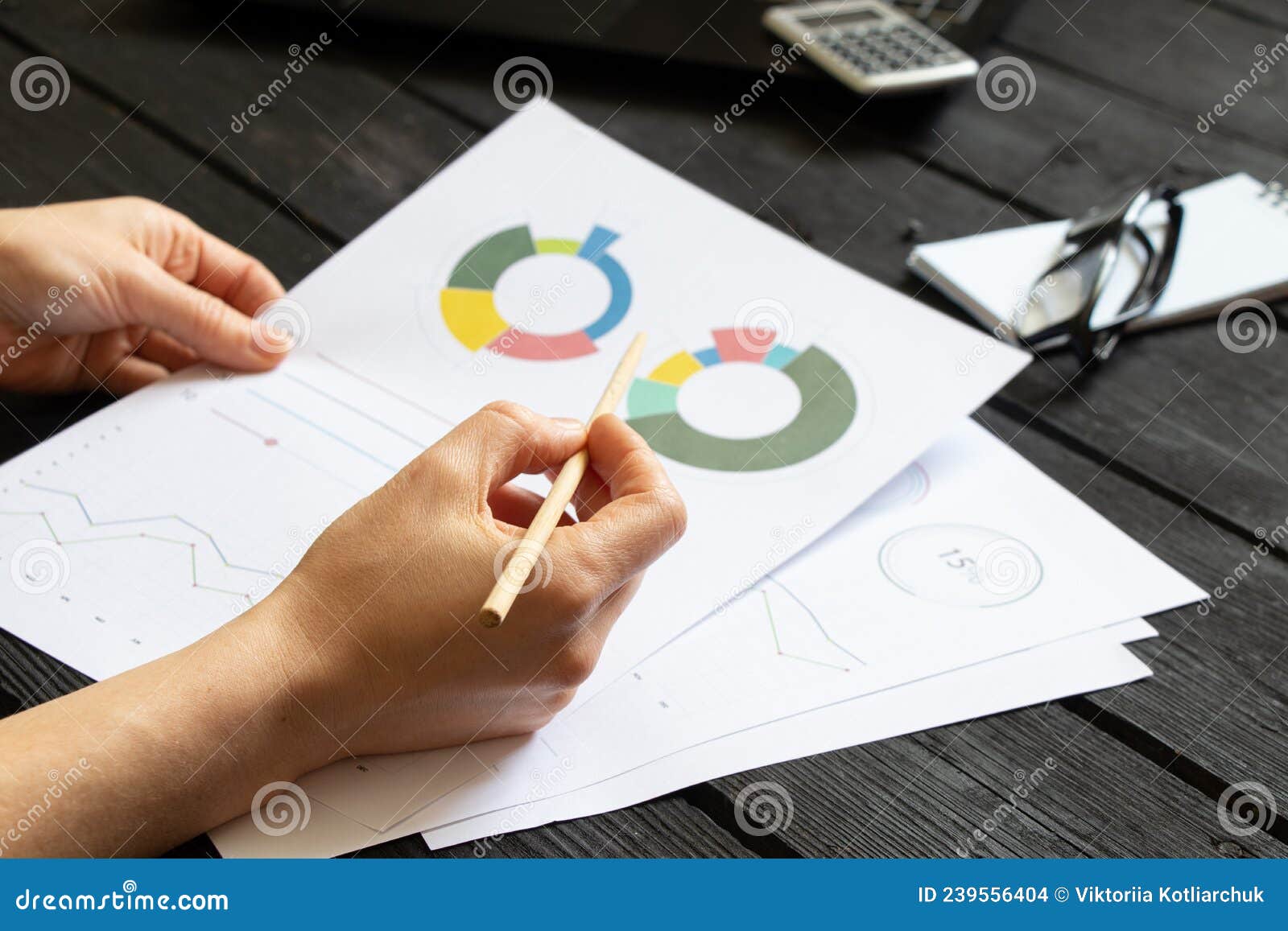 reports and histograms on paper on the table in the hands of a girl, analytics and statistics on paper, business