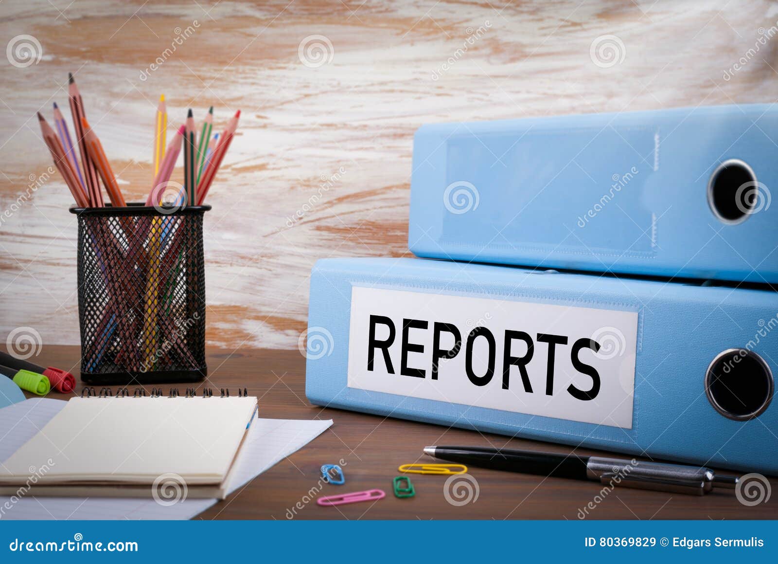 reports, office binder on wooden desk. on the table colored pencils, pen, notebook paper