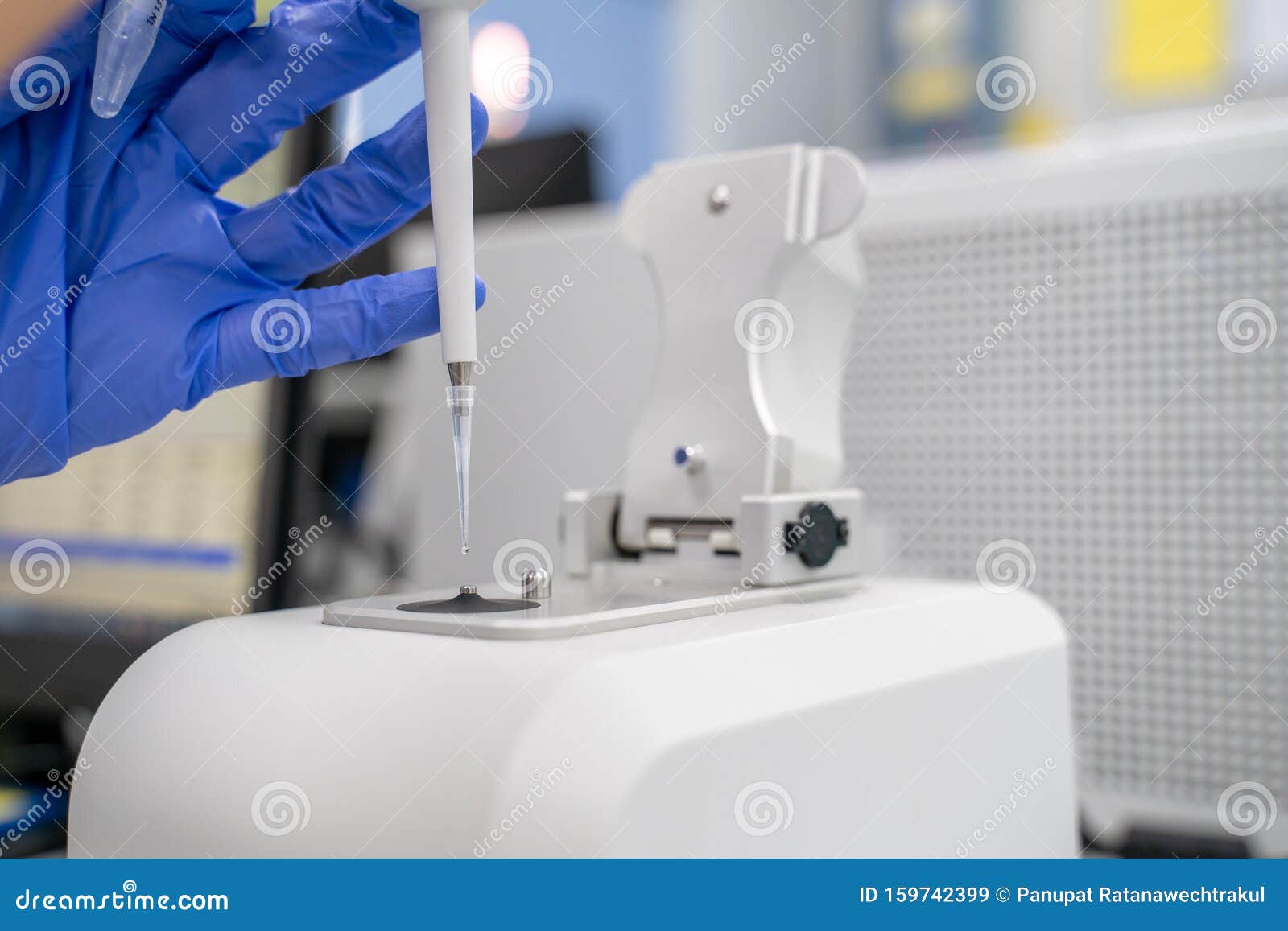 the researcher drops 2 micro-liters of the sample on pedestal to measures the rna concentration and quality using the nano drop