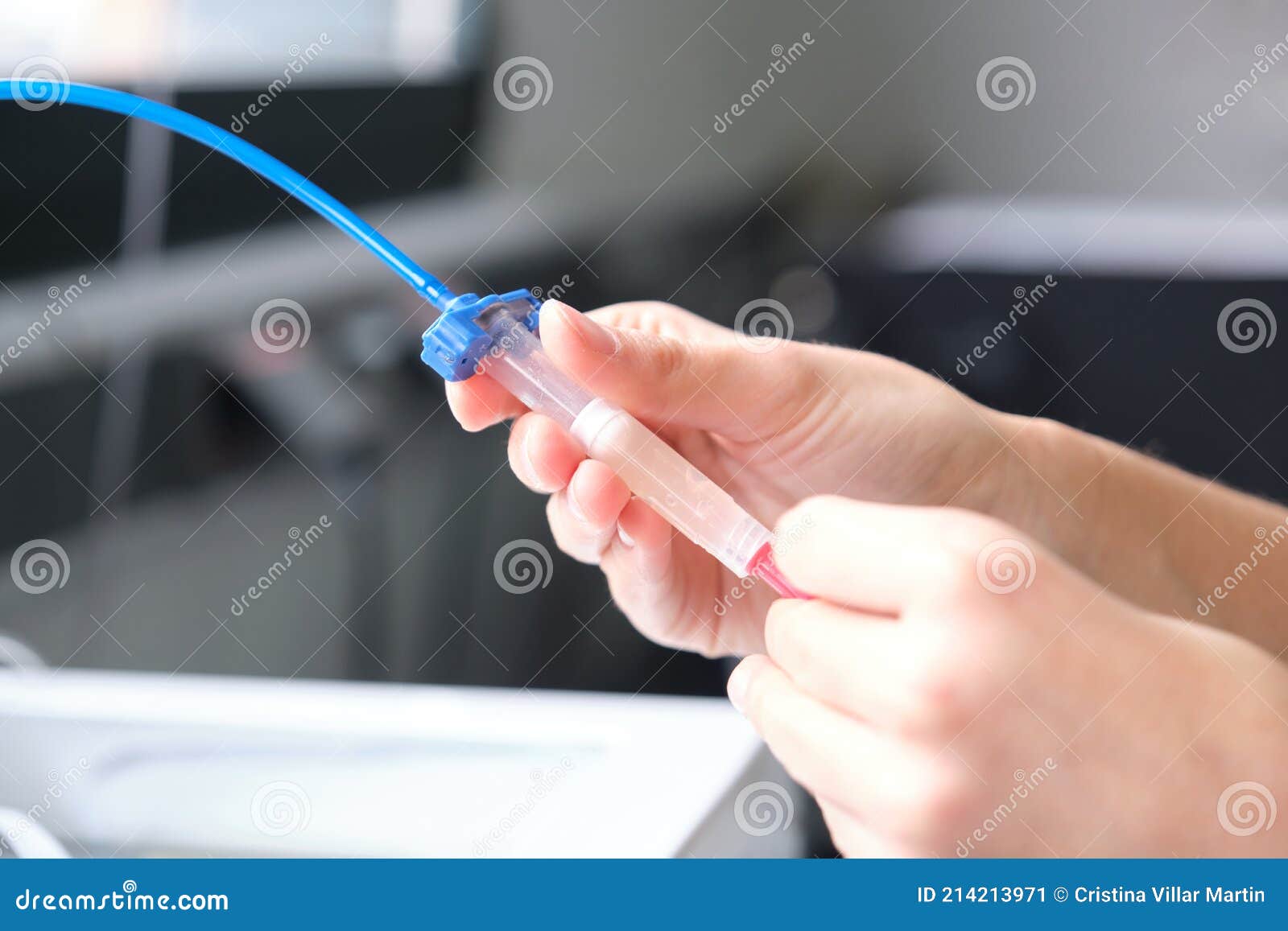 researcher loading the ink cartridge of a 3d bioprinter to 3d print cells onto an electrode