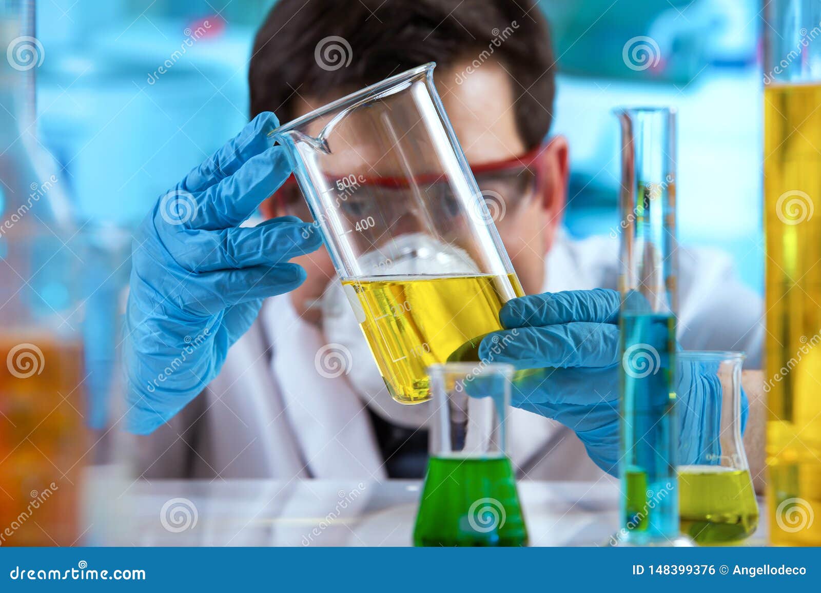 researcher measuring sample in beaker of liquids in the research lab