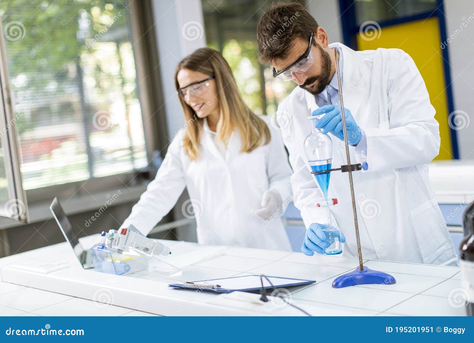 Researchers Working with Blue Liquid at Separatory Funnel Stock Image