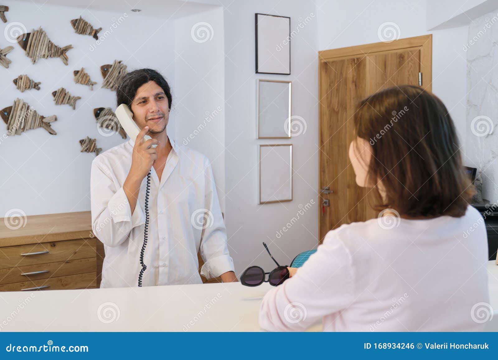 Resort Hotel Front Desk Woman Guest Talking To Man Working At