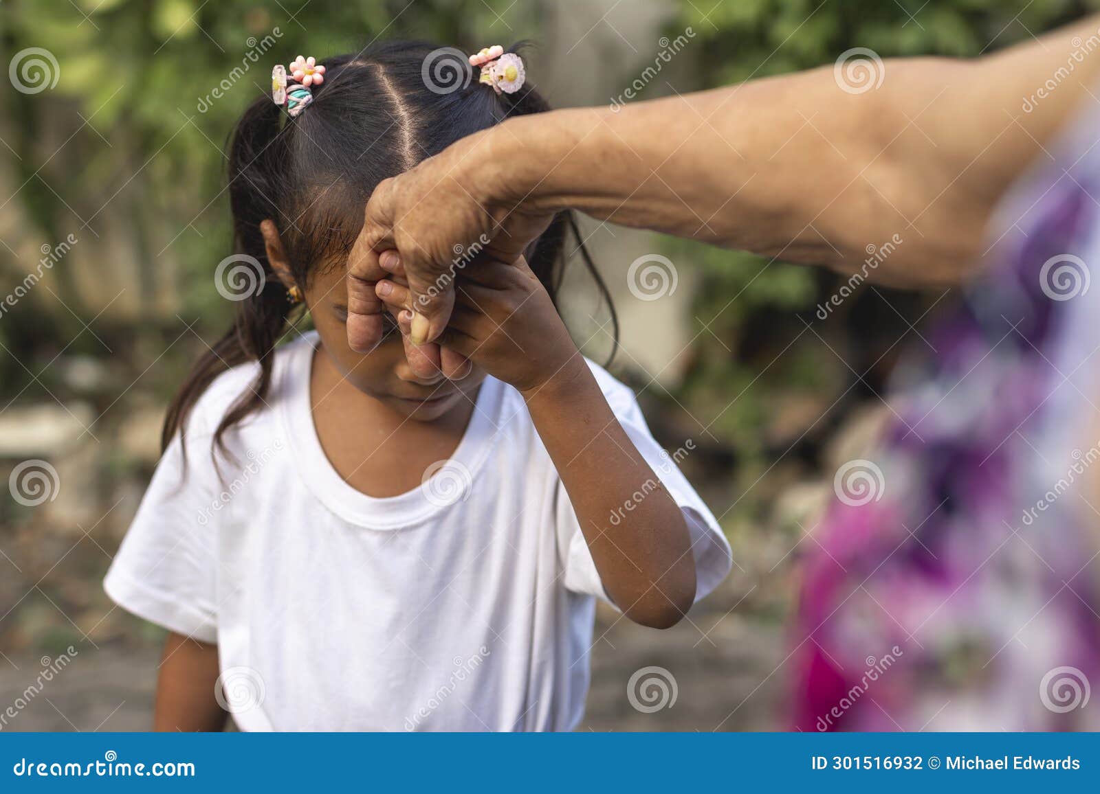 a respectful young girl does the mano po gesture to his grandmother. a sign of respect and reverence to your elders in the