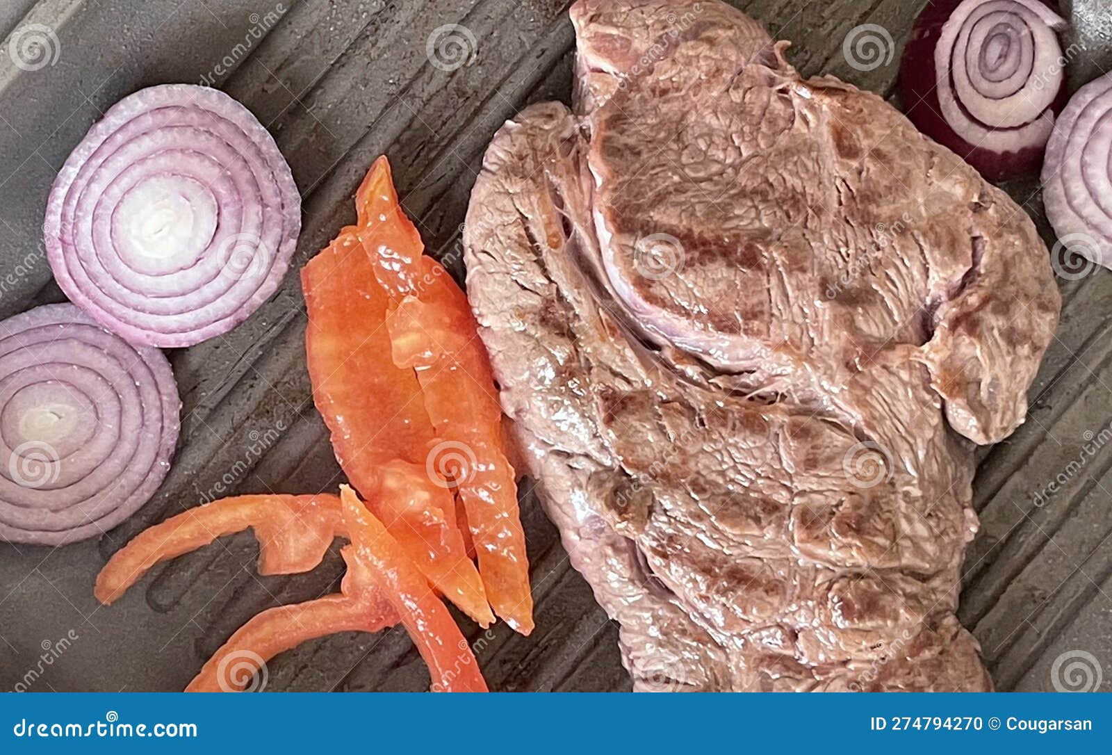 Restaurant Cooked Beef Steaks, Onion and Tomato on Iron Plate Stock