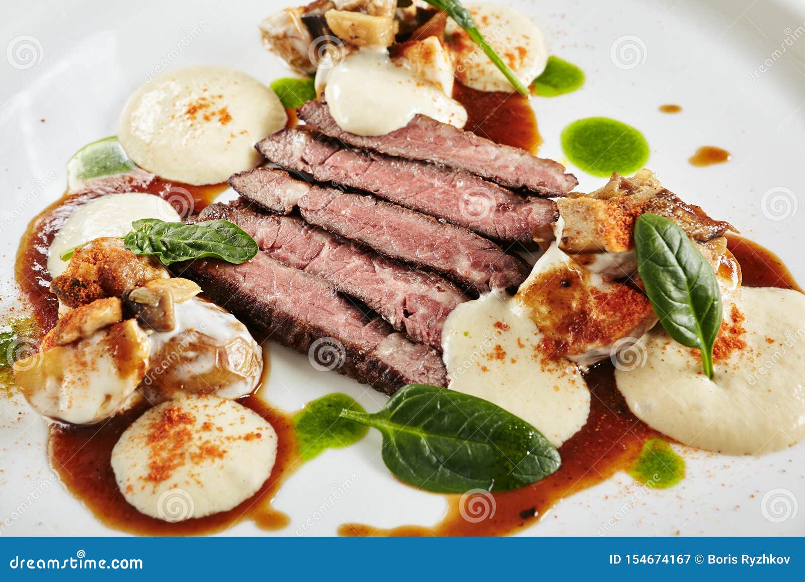 restaurant plate of black angus beef fillet with warm potatoes in cheese sauce and mushroom espuma