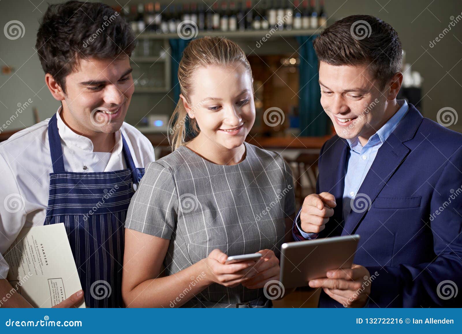 Restaurant Team Discussing Menu Looking at Digital Tablet Stock Photo