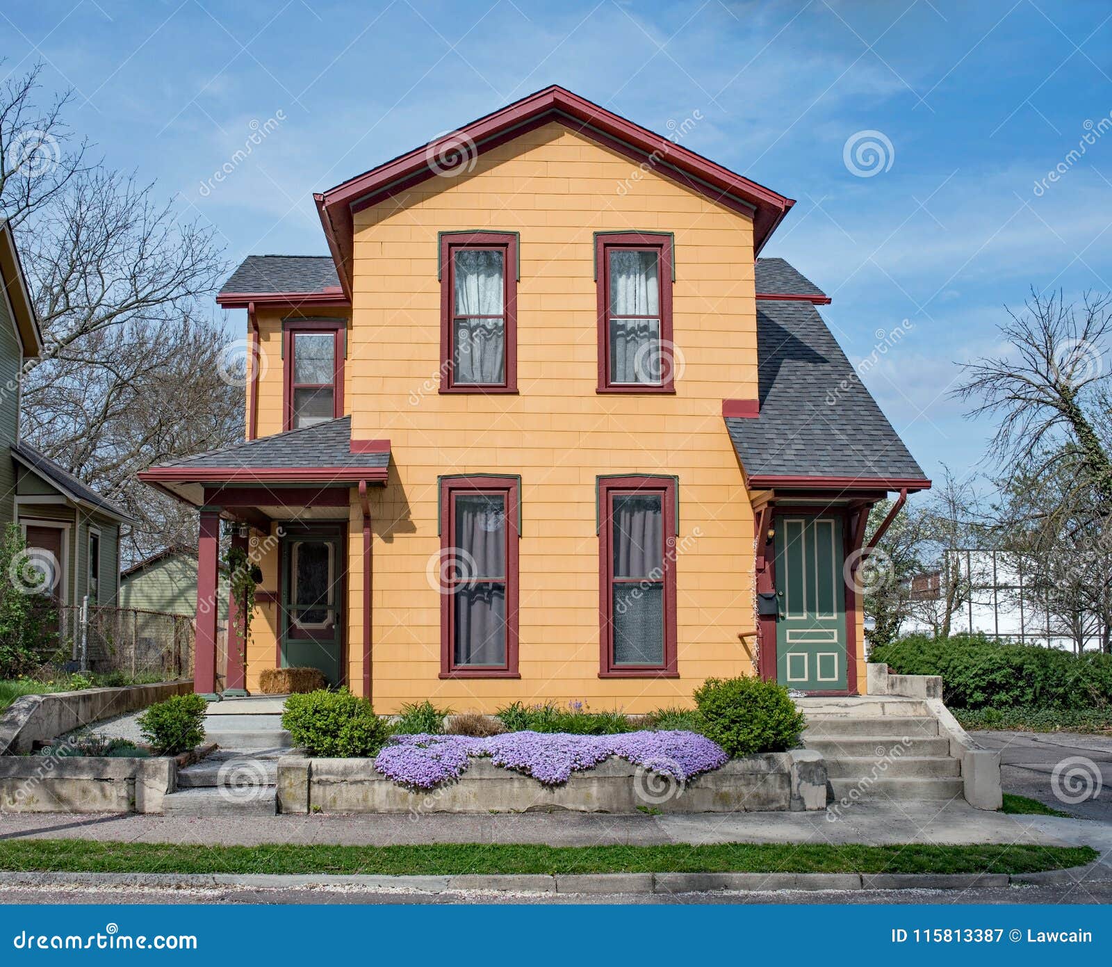 restored orange duplex house with purple phlox