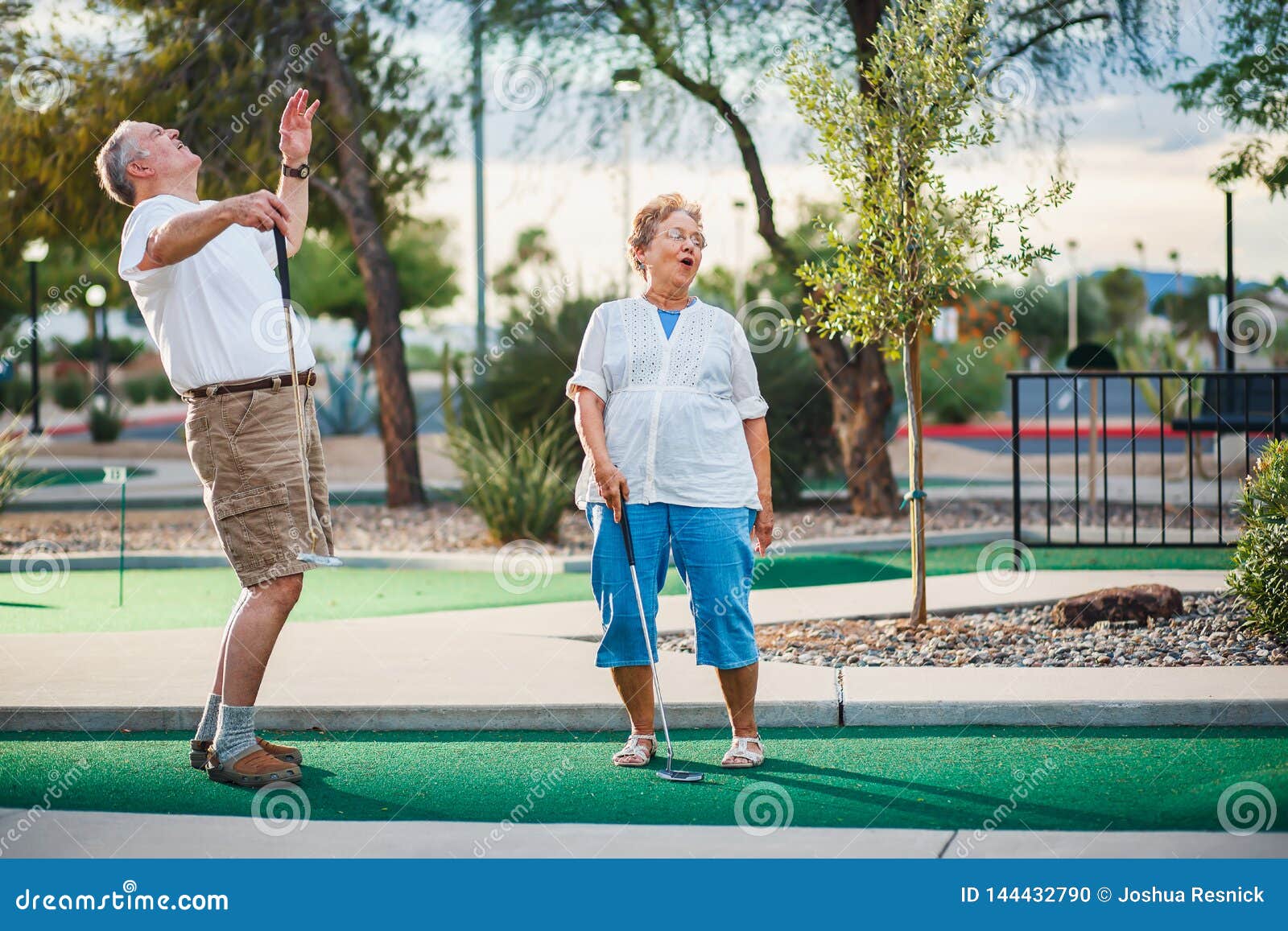 retired couple having fun playing mini golf