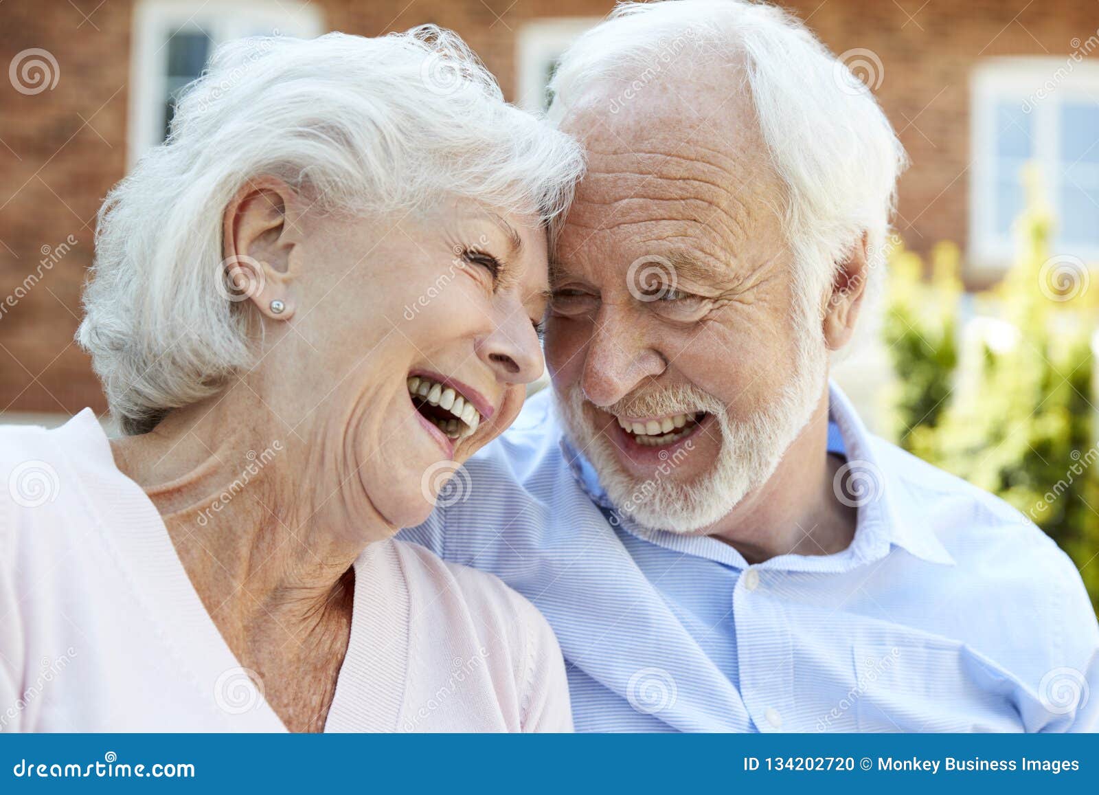 retired couple sitting on bench and talking in assisted living facility