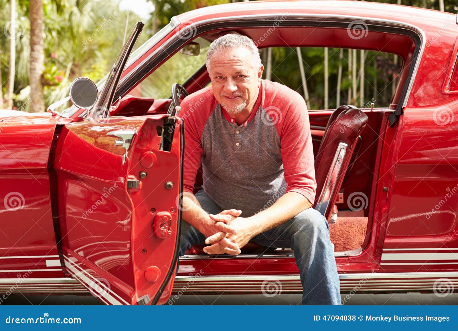 retired senior man sitting in restored classic car