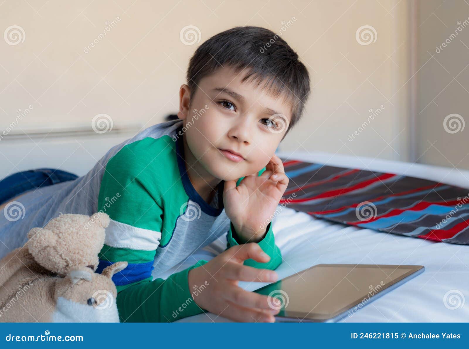 criança jogando jogos online na internet no quarto, retrato de menino  usando tablet digitando ou conversando com amigos de manhã, infância  sentada na cama fazendo lição de casa, criança da escola com