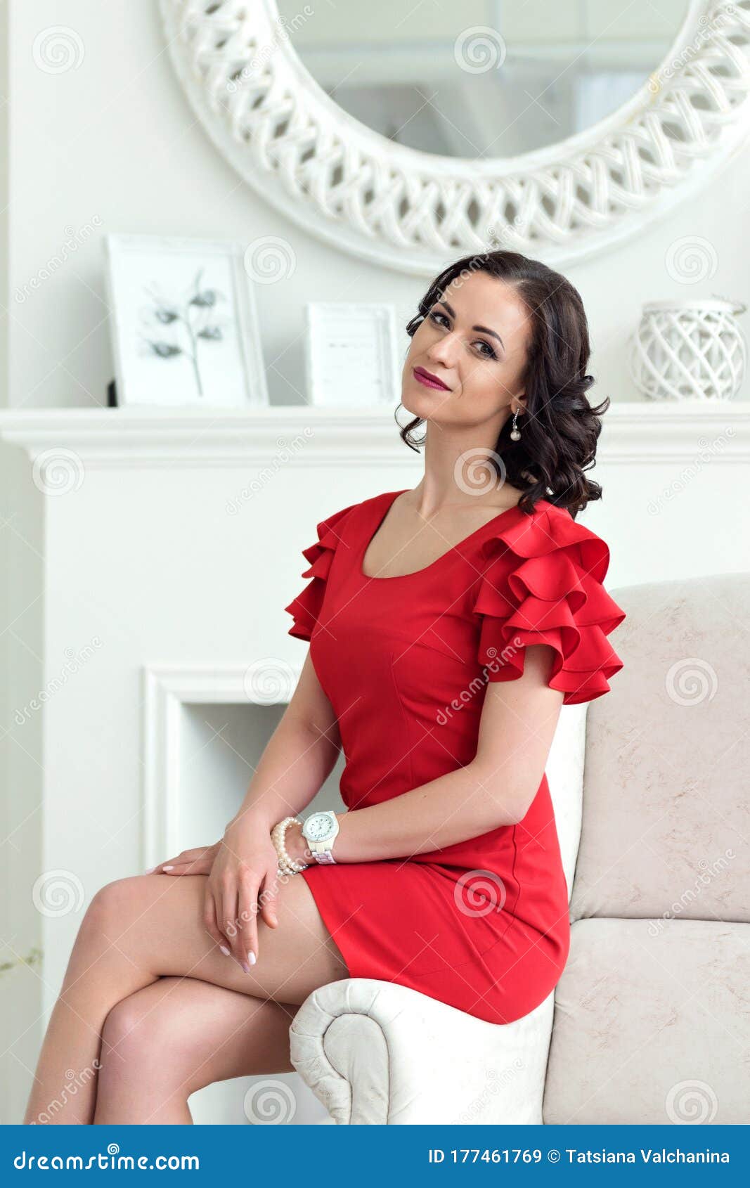 Retrato De Elegante Joven Y Sofisticada Morena Con Vestido Rojo Corto Sentado En El Brazo De Una Silla Imagen de archivo - Imagen de rizado: