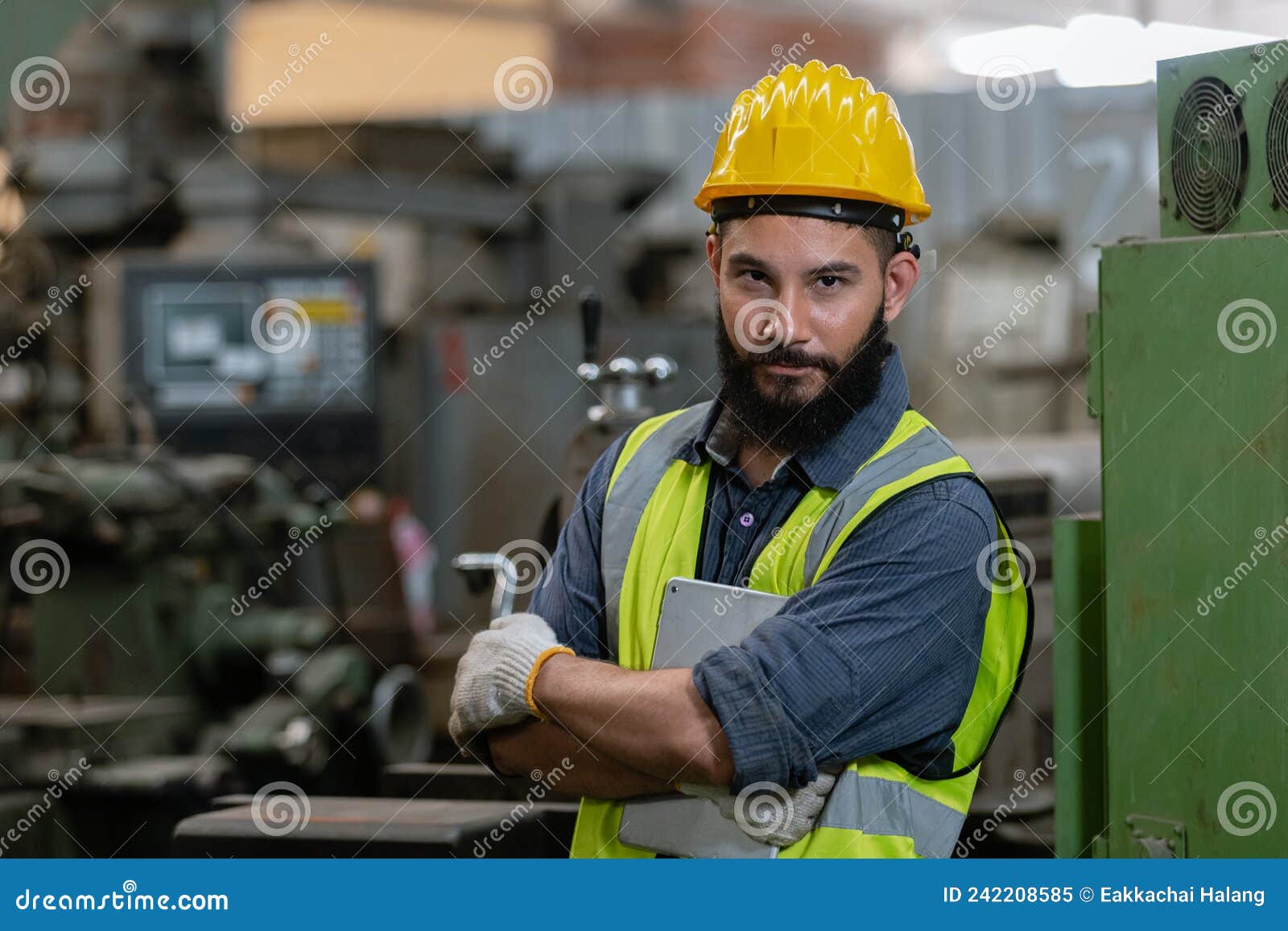 Un hombre con barba, casco y ropa de trabajo. retrato de un
