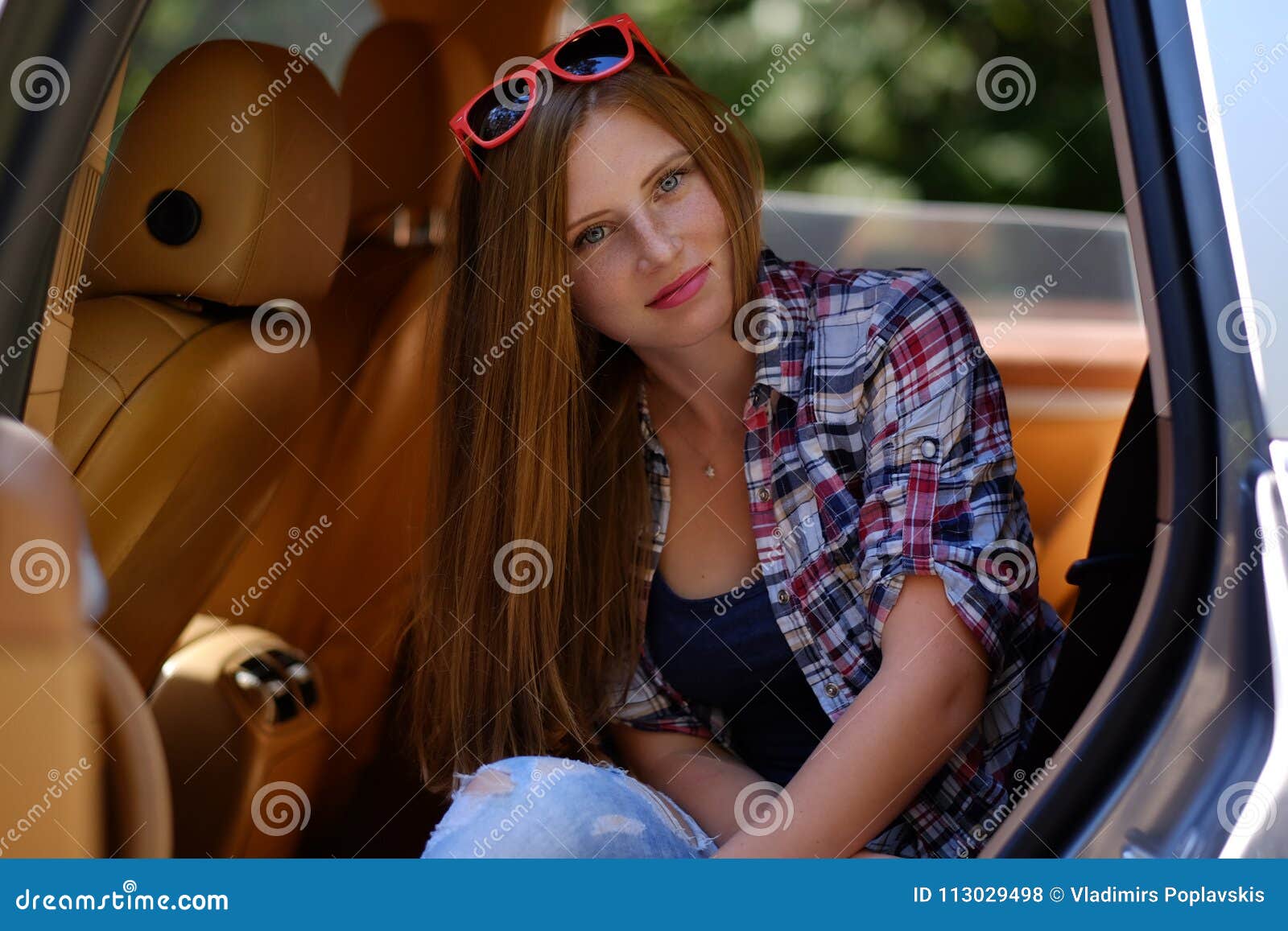 Retrato de la hembra pecosa en un coche en asiento trasero