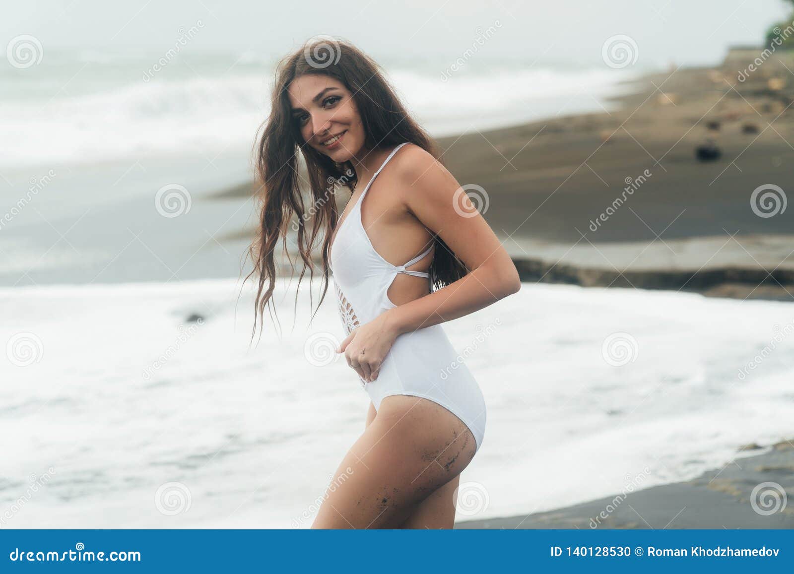 Retrato De La Mujer Joven En El Traje De Baño Blanco Presenta En La Playa De La Arena Foto de archivo - de pechos, negro: