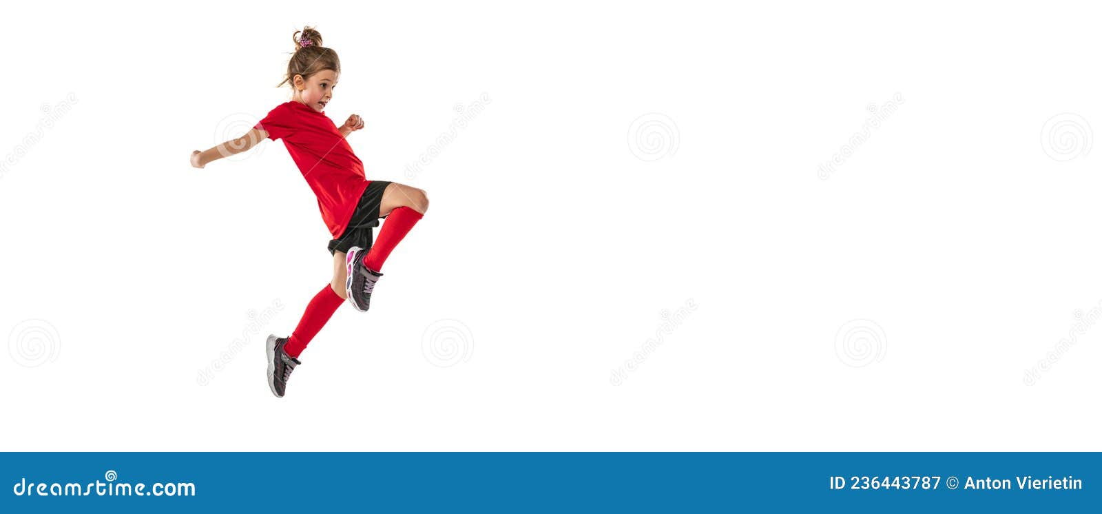 Niña bonita haciendo gimnasia con una pelota sobre fondo blanco.