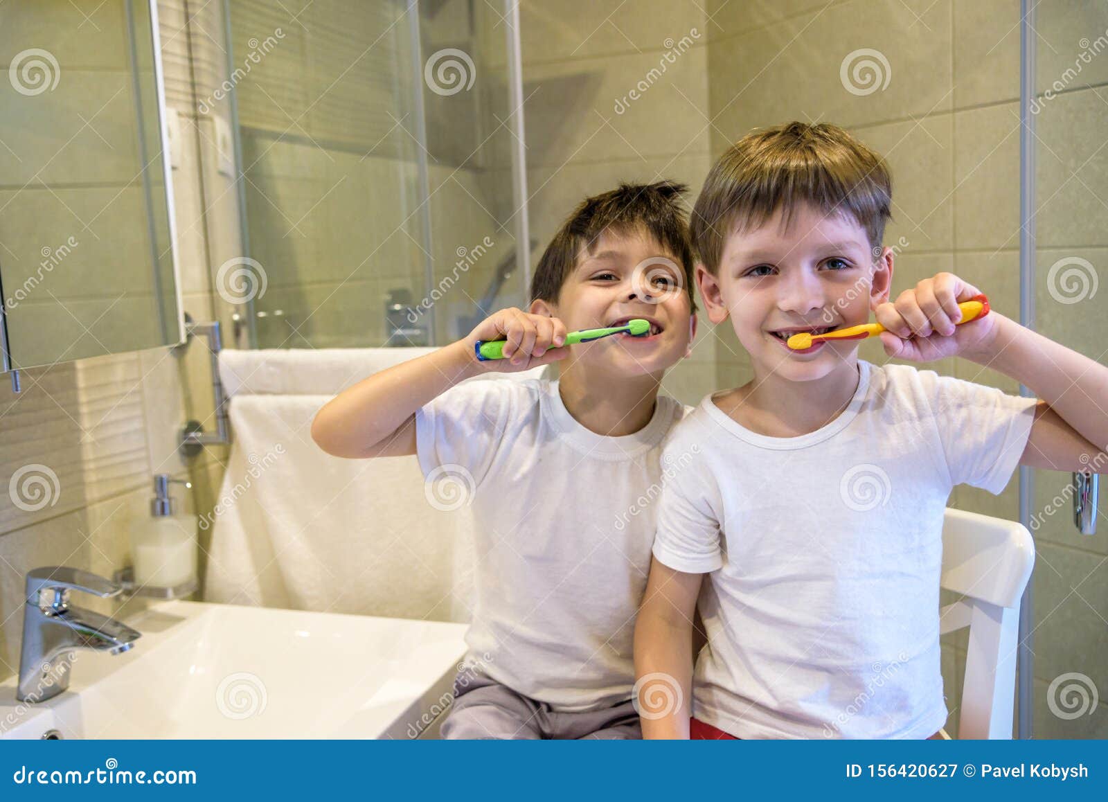 Retrato de mellizos niÃ±os pequeÃ±os hermano pequeÃ±o en el baÃ±o lavar la cara lavar los dientes con cepillo de dientes jugando