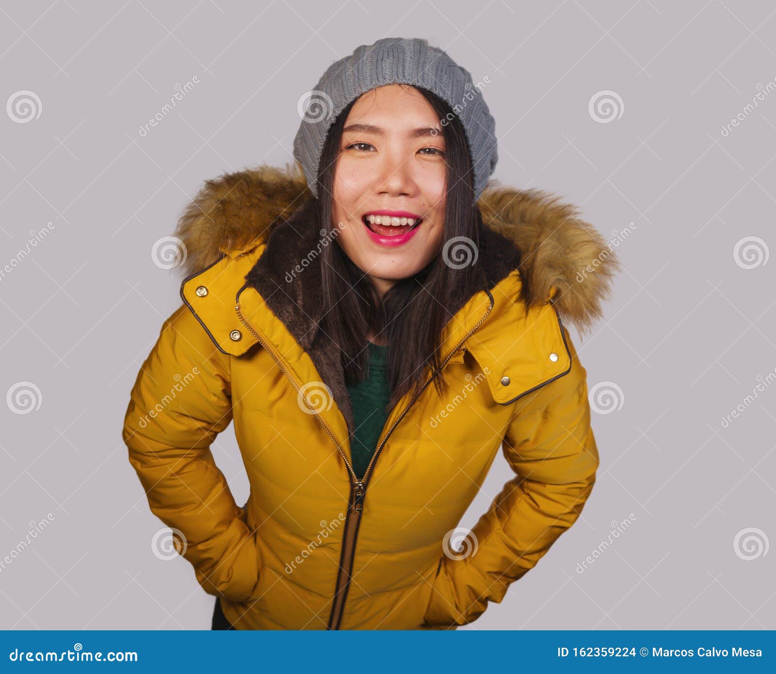 Retrato De Moda Aislado De Joven Hermosa Y Feliz Mujer Asiática Con Sombrero De Invierno Y Cálida Casaca De Plumas Amaril de archivo - Imagen de belleza, manera: 162359224