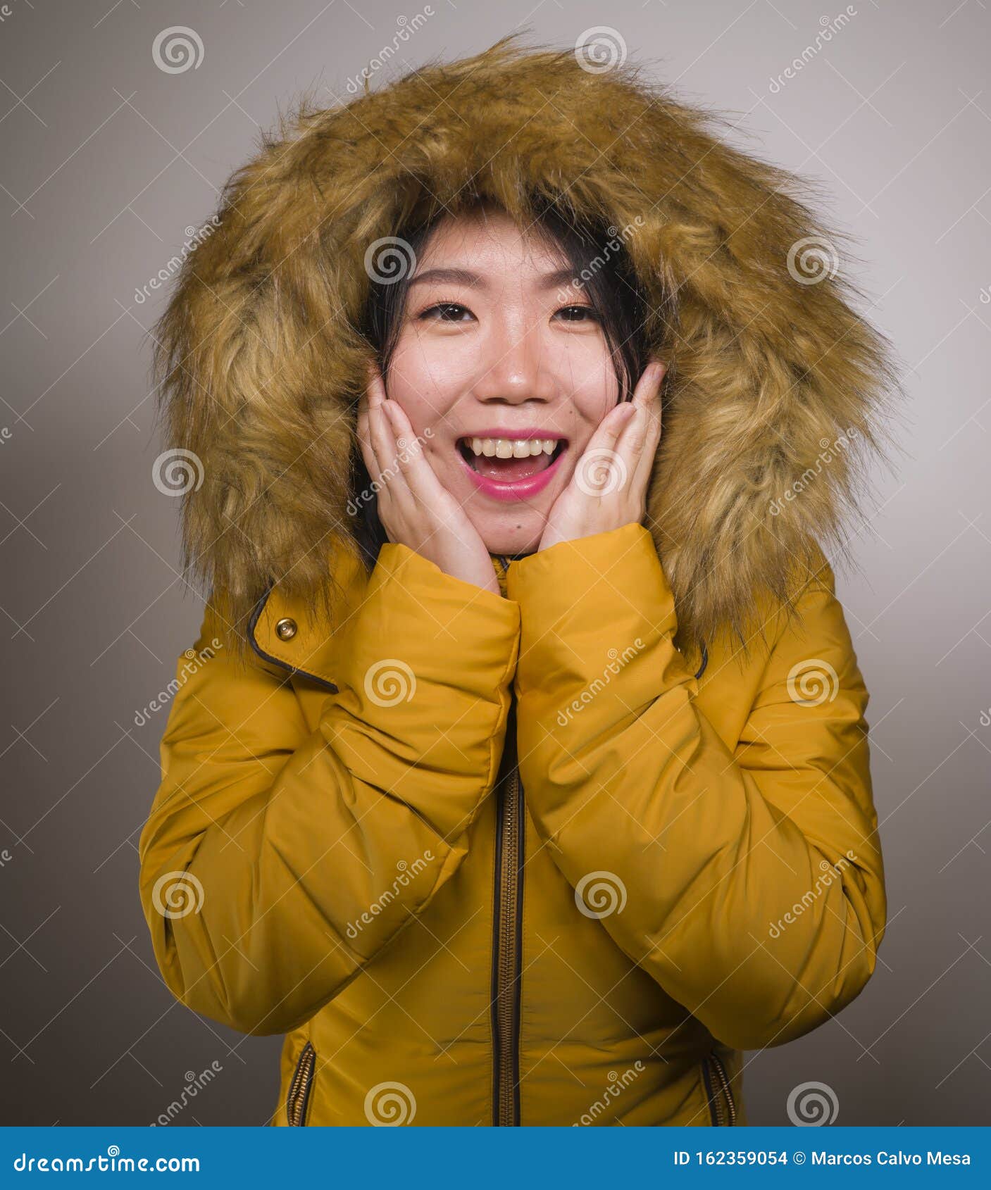 Retrato De Moda Invernal De Una Joven Y Hermosa Y Feliz Mujer Asiática China En Una Cálida Chaqueta De Plumas Amarillas Con Capuc Foto de archivo - Imagen de chino, disfrutar: