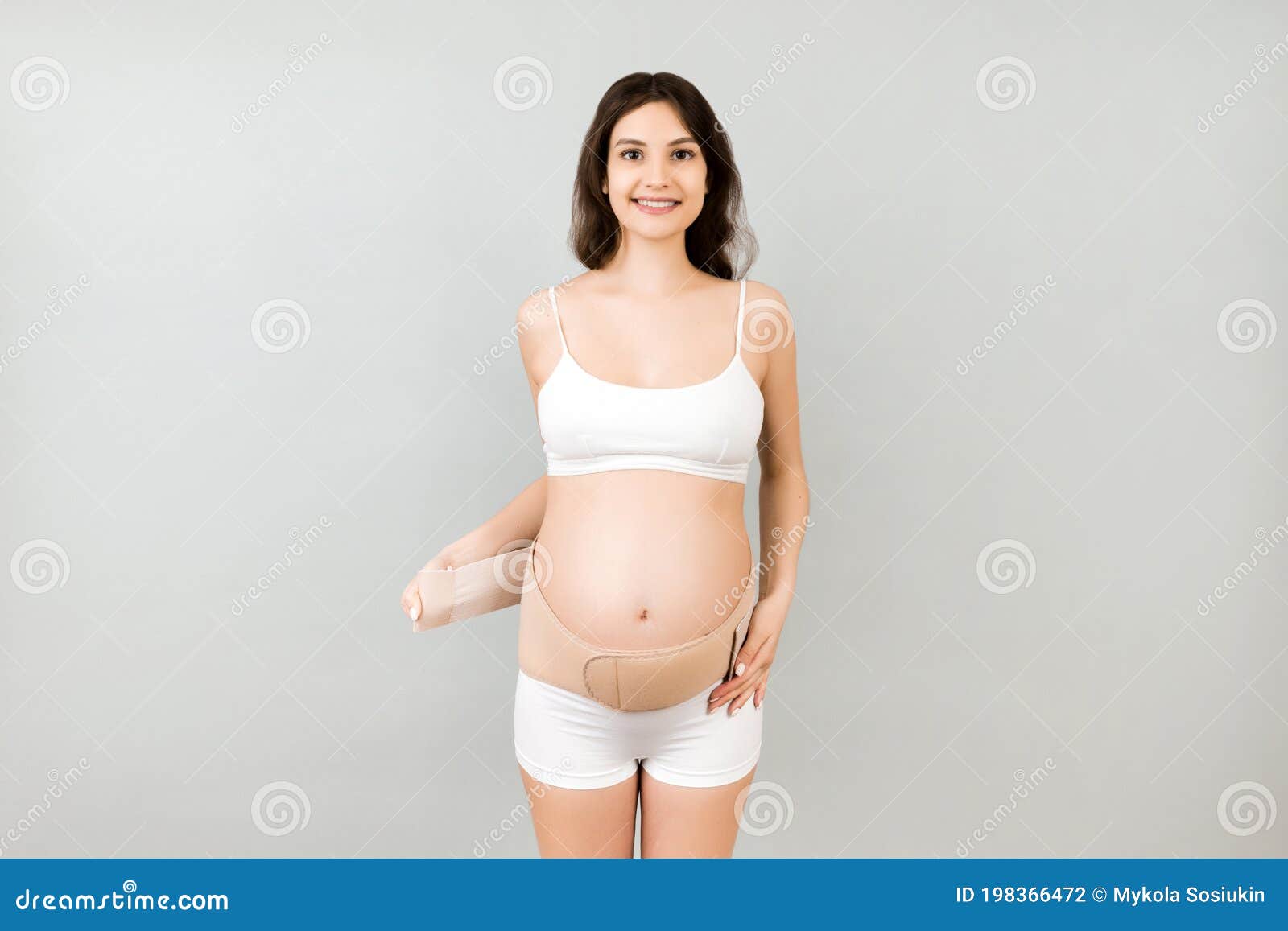 Retrato De Mujer Embarazada En Ropa Interior Venda Ortopédica Para Reducir El Dolor En La Espalda En El Fondo Gris Con Espacio De Foto de archivo Imagen de abdominal, dolor:
