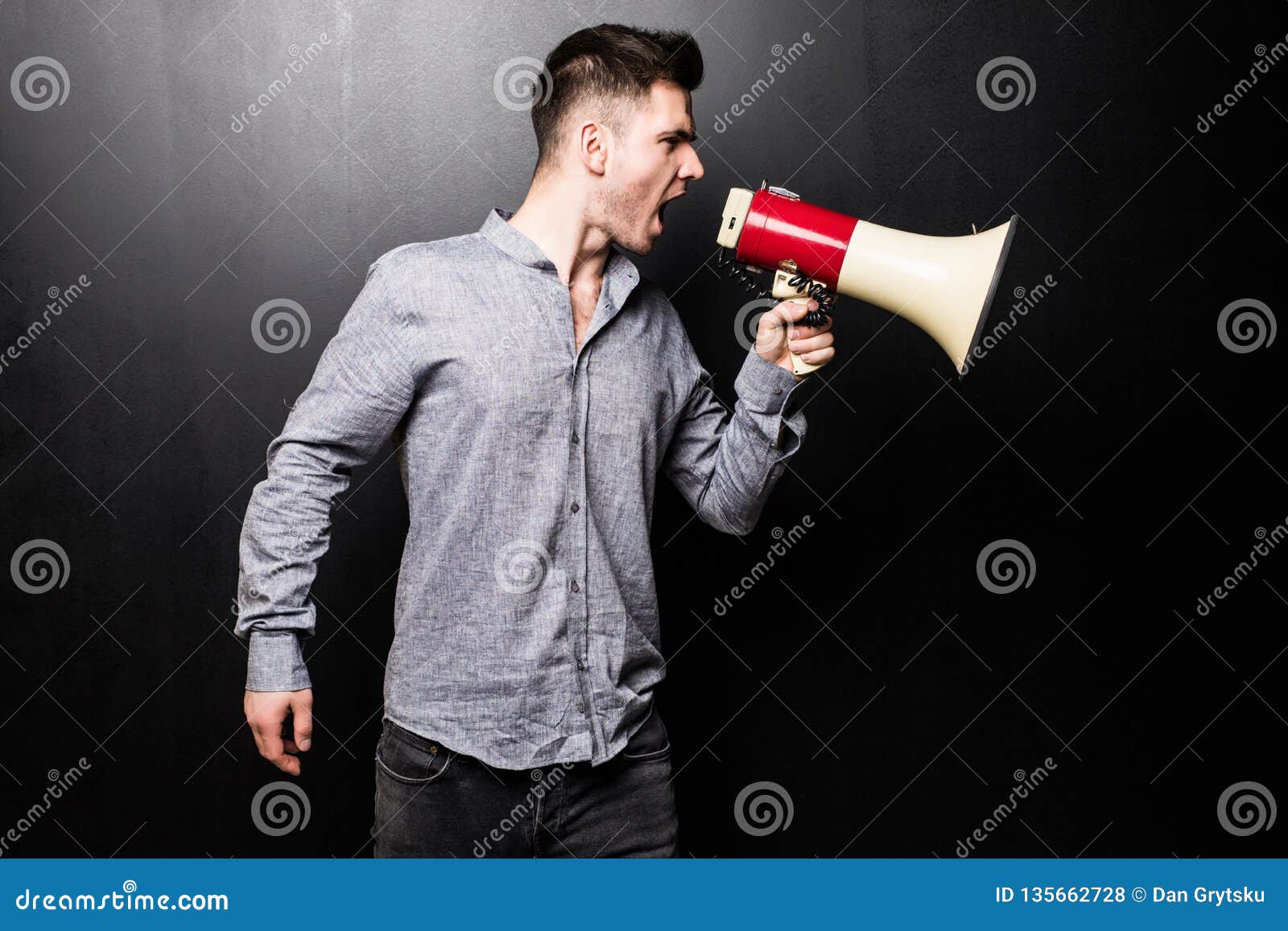 Retrato De Um Jovem Bonito Gritando No Megafone Sobre Fundo Preto Foto