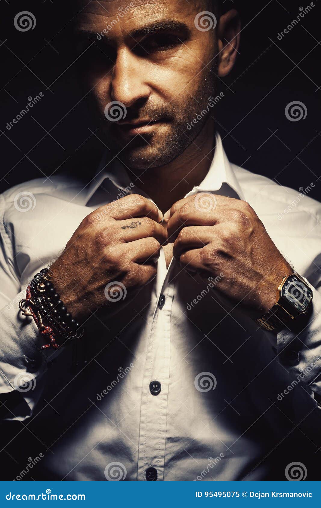 Retrato de un hombre. El hombre adulto consigue pulseras interesantes vestidas, que llevan y reloj digital viejo