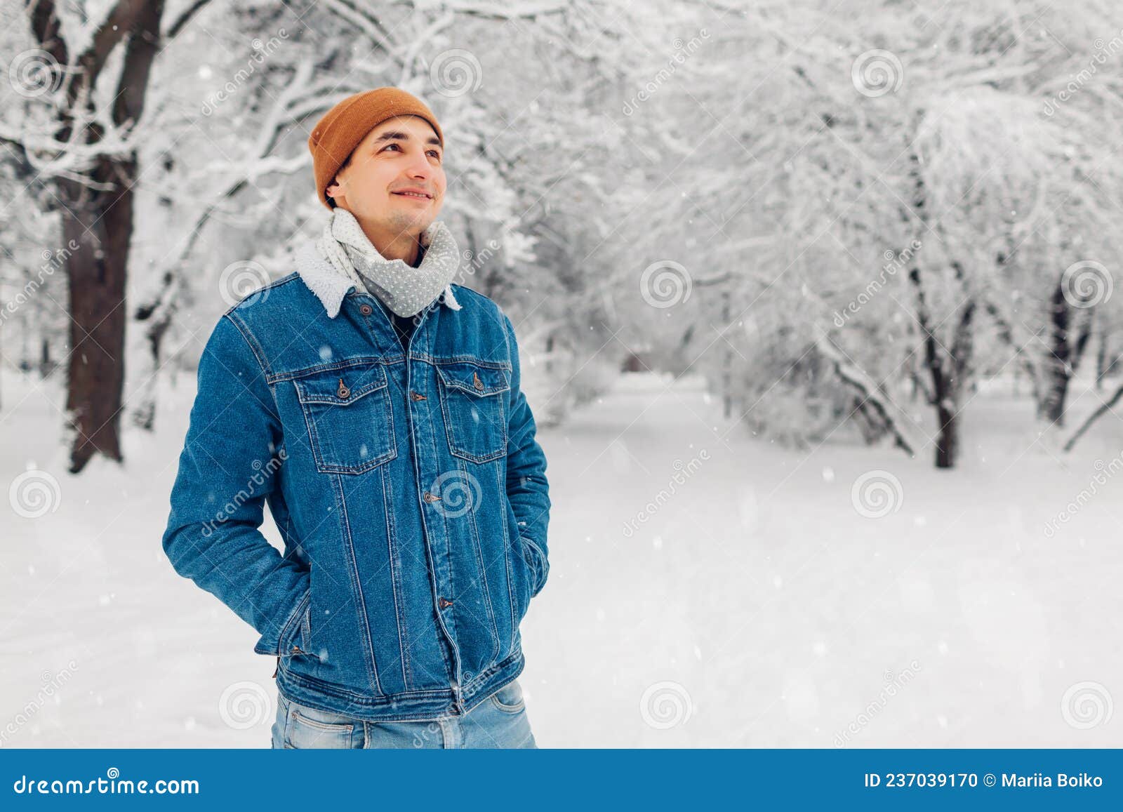 Retrato de hombre joven en ropa de abrigo en el bosque de invierno bebiendo  té caliente al aire libre del termo senderismo turismo