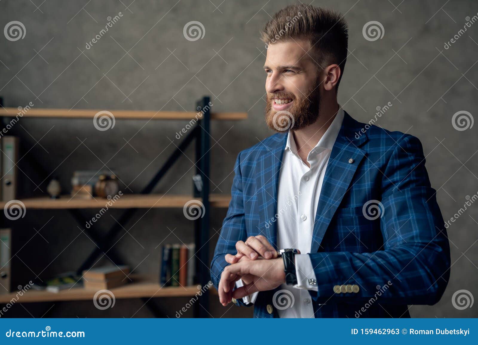 Retrato De Un Hombre Inteligente Y Responsable Con Un Moderno Peinado Mirando El Reloj En La Muñeca Sobre Una Oficina Borrosa Apr Imagen de archivo - Imagen de peinado, reloj: 159462963