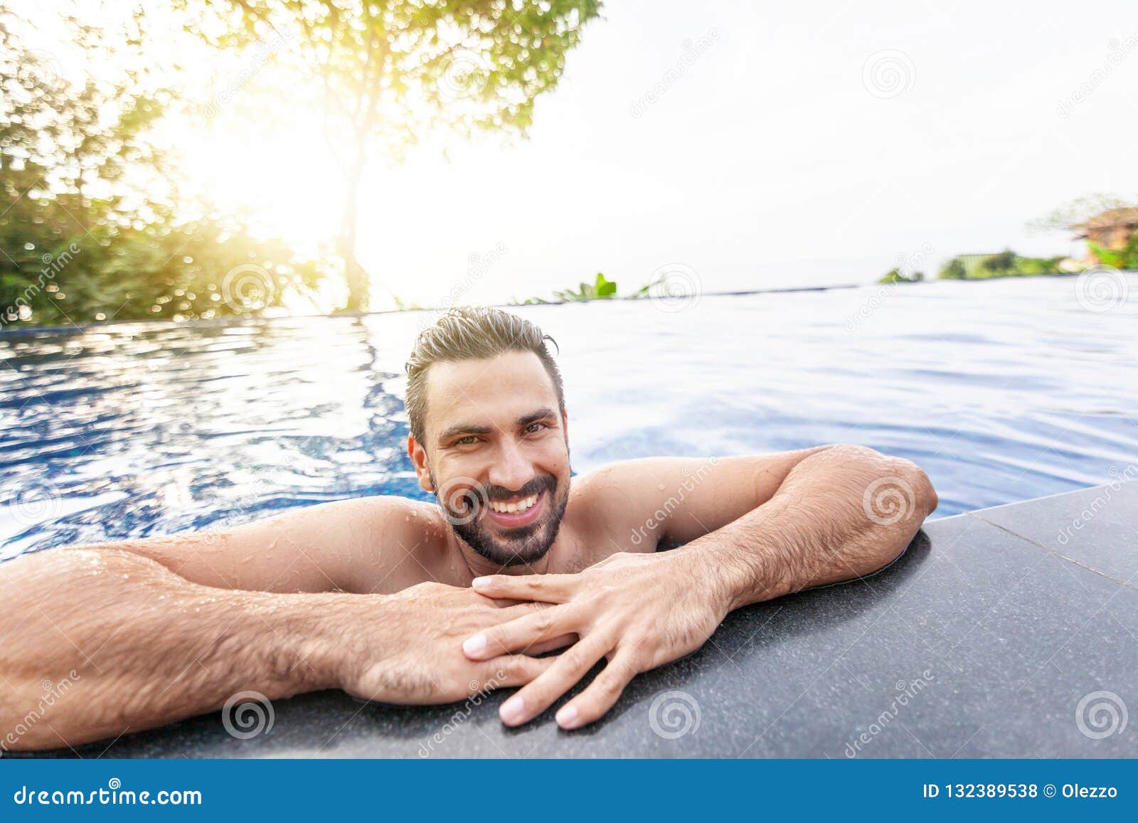 Complejo de piscina. hombre guapo en vacaciones de verano. hombre con gafas  de sol relajándose en la piscina.