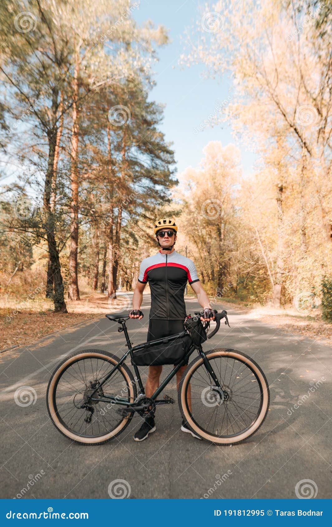 Retrato De Un Joven Con Una Bicicleta Parada En La Carretera En El Bosque  De Otoño Y Posando En La Cámara. Hombre Camina En Bicicl Imagen de archivo  - Imagen de bici