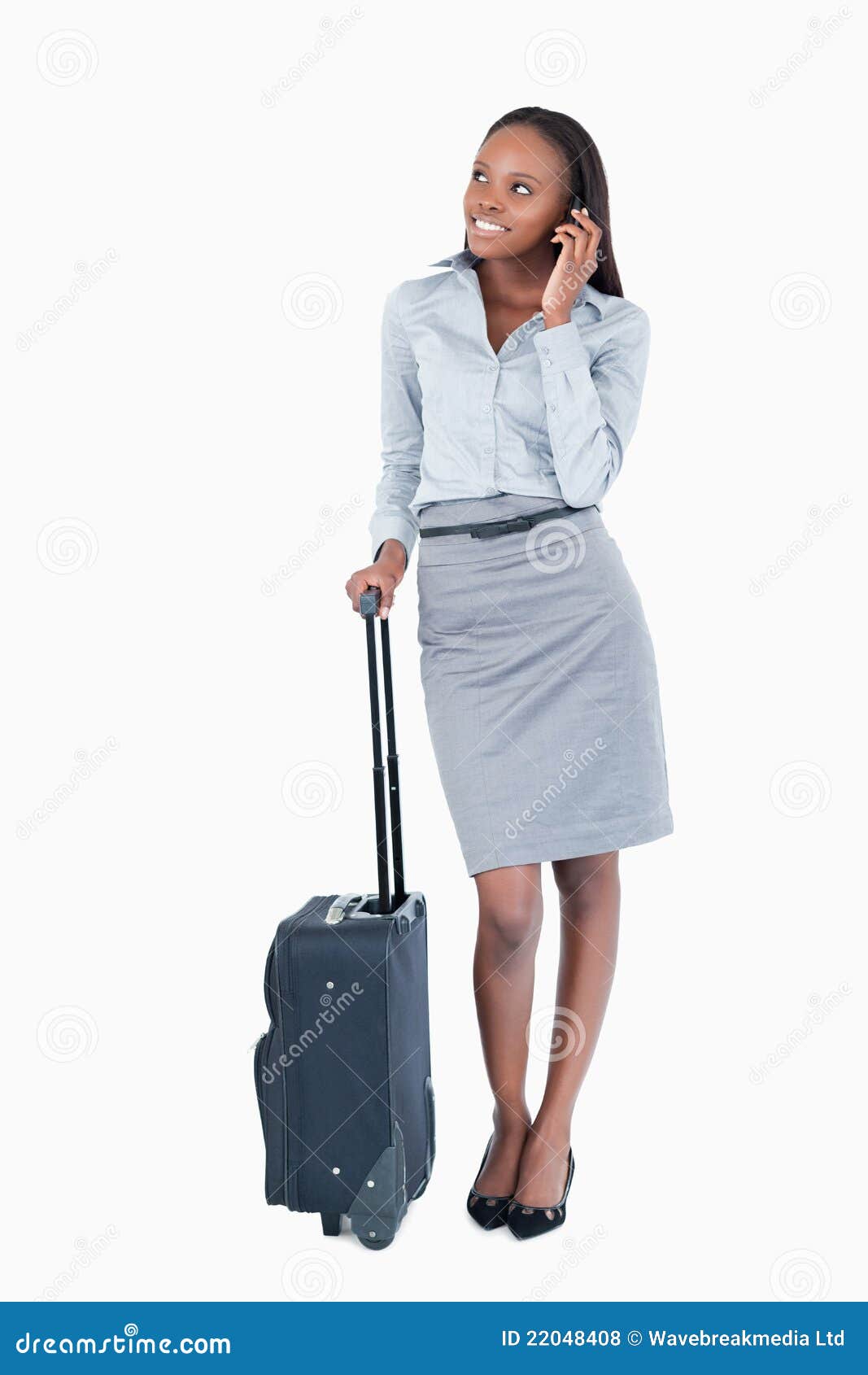 Retrato de una empresaria linda con una maleta que hace una llamada de teléfono contra un fondo blanco