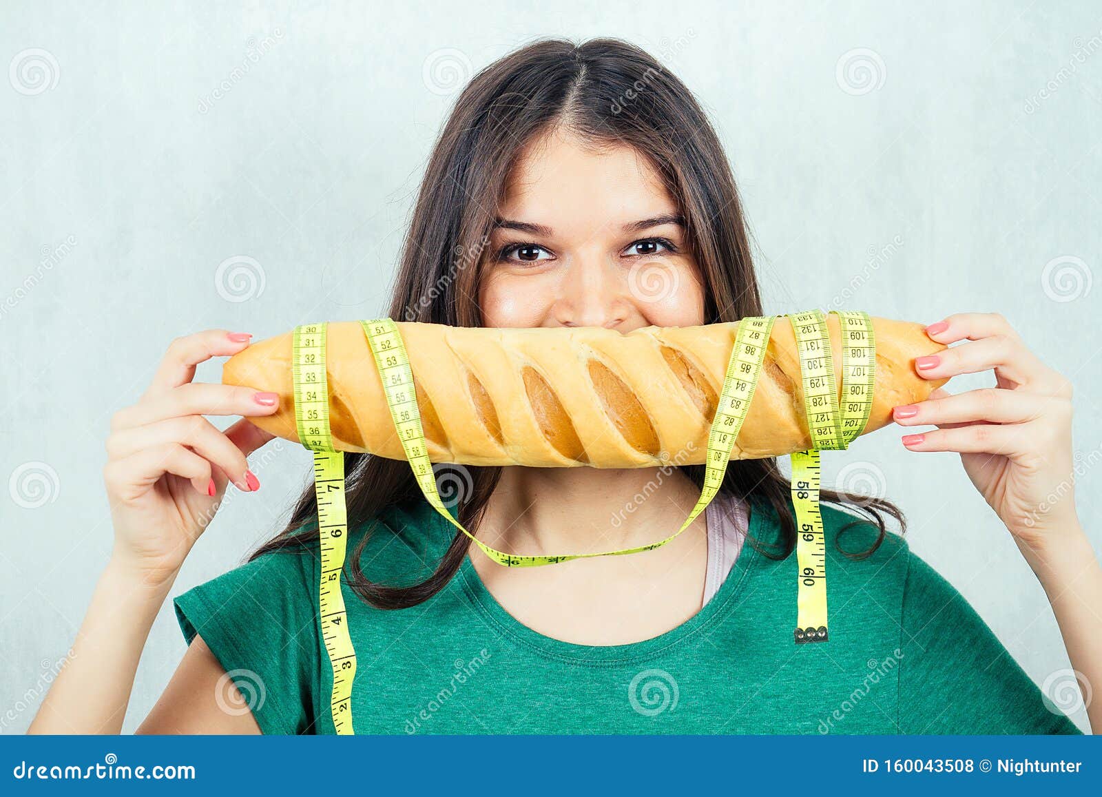 Retrato De Una Mujer Hambrienta, Joven Y Bella Morena Sosteniendo Un Pan De Moño Alto En CalorÃas Con Una Cinta Dosificadora. Co Foto de archivo - Imagen de bella, dosificadora: 160043508