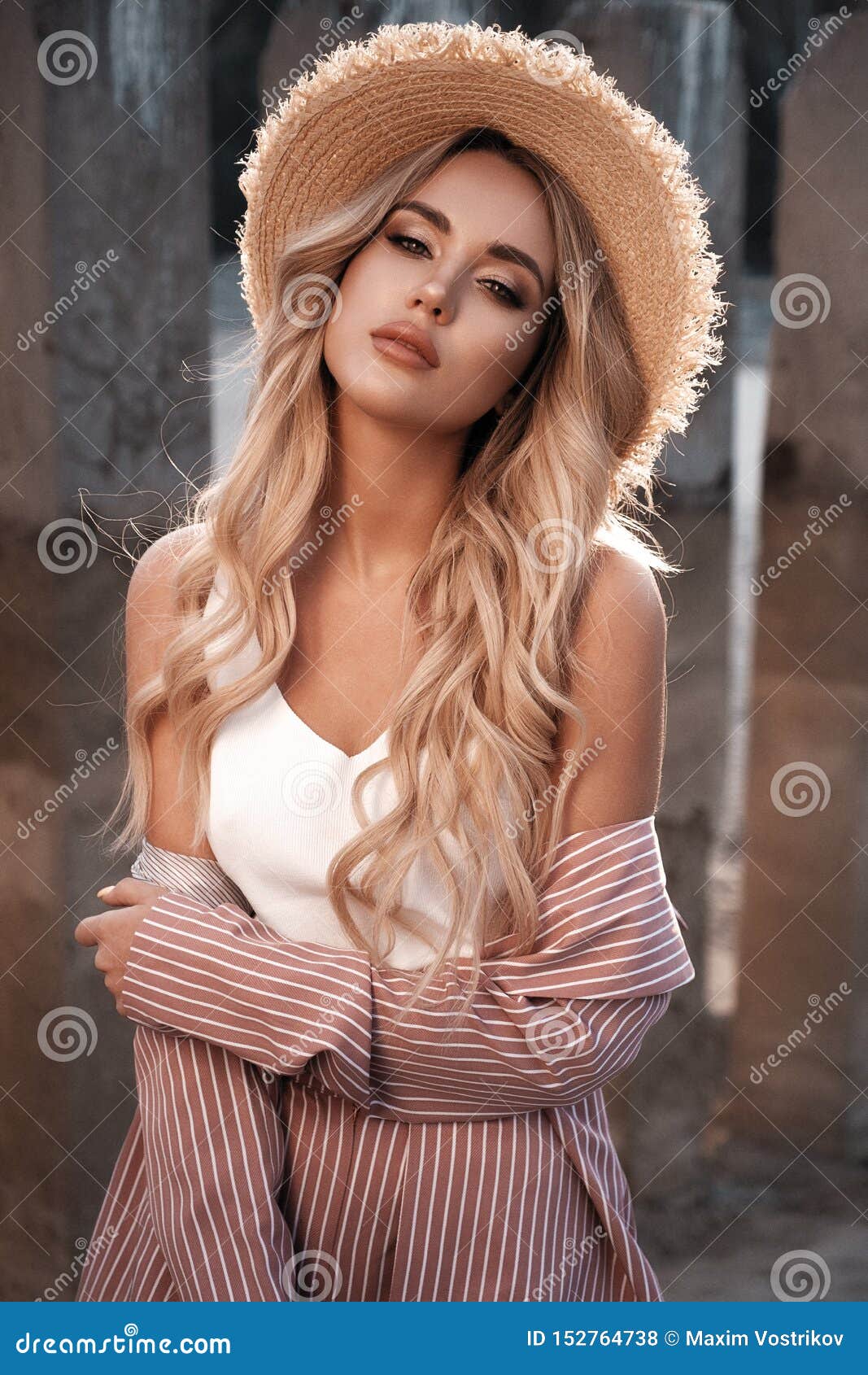 Retrato de una mujer joven hermosa, atractiva y elegante con el pelo rubio flojo largo en un sombrero de paja Paisaje del campo, naturaleza Verano, photoshoot al aire libre de la forma de vida del verano