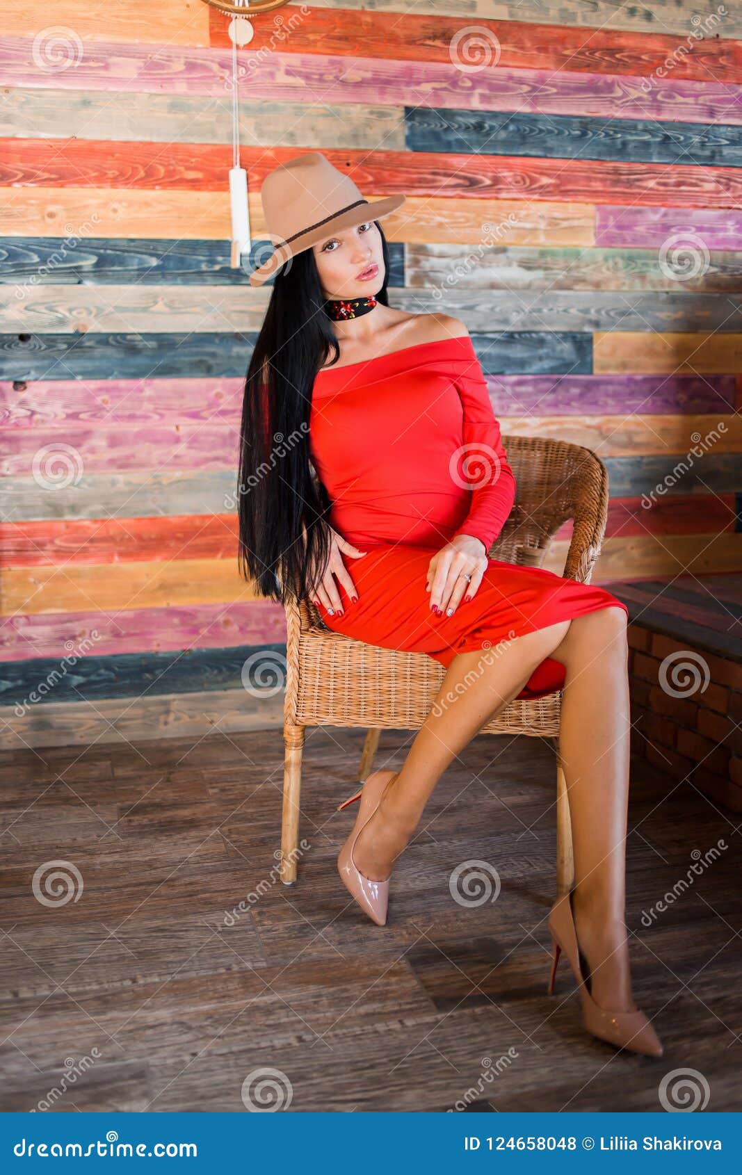 Retrato De Una Mujer Elegante Que Lleva Un Vestido Rojo, Zapatos Beige Y Un Sombrero Y Sentándose En Una Silla Foto de archivo - Imagen de atractivo, 124658048